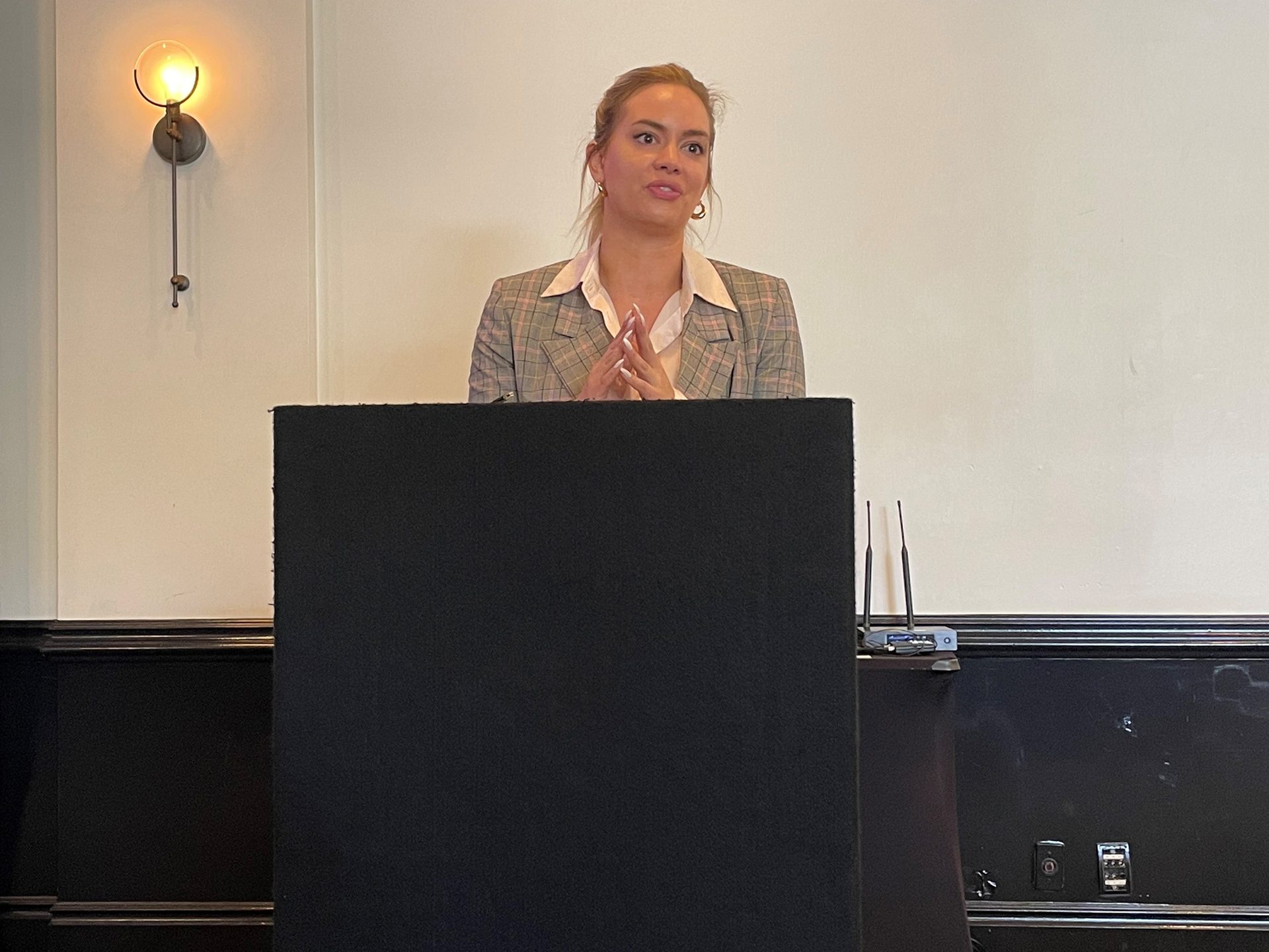 Public address system, Audio equipment, Hair, Face, Microphone, Podium, Lectern, Coat, Standing, Spokesperson