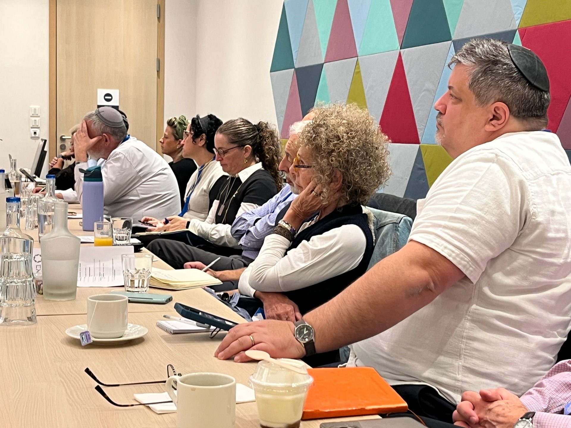 Diverse group of people attending a meeting around a table.