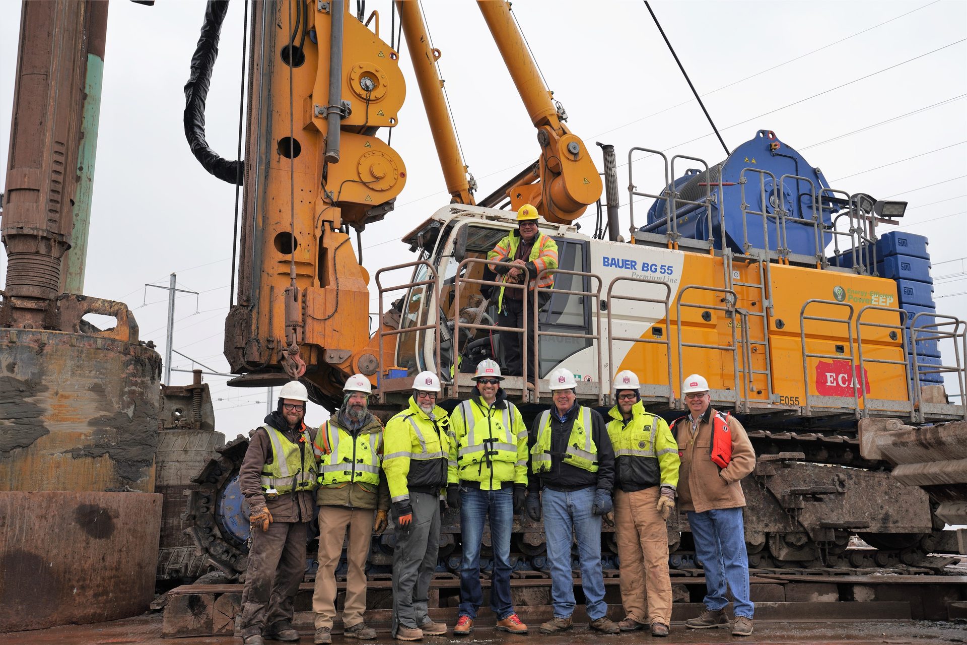 Mode of transport, High-visibility clothing, Hard hat, Workwear, Vehicle, Yellow, Asphalt, Helmet, Crane