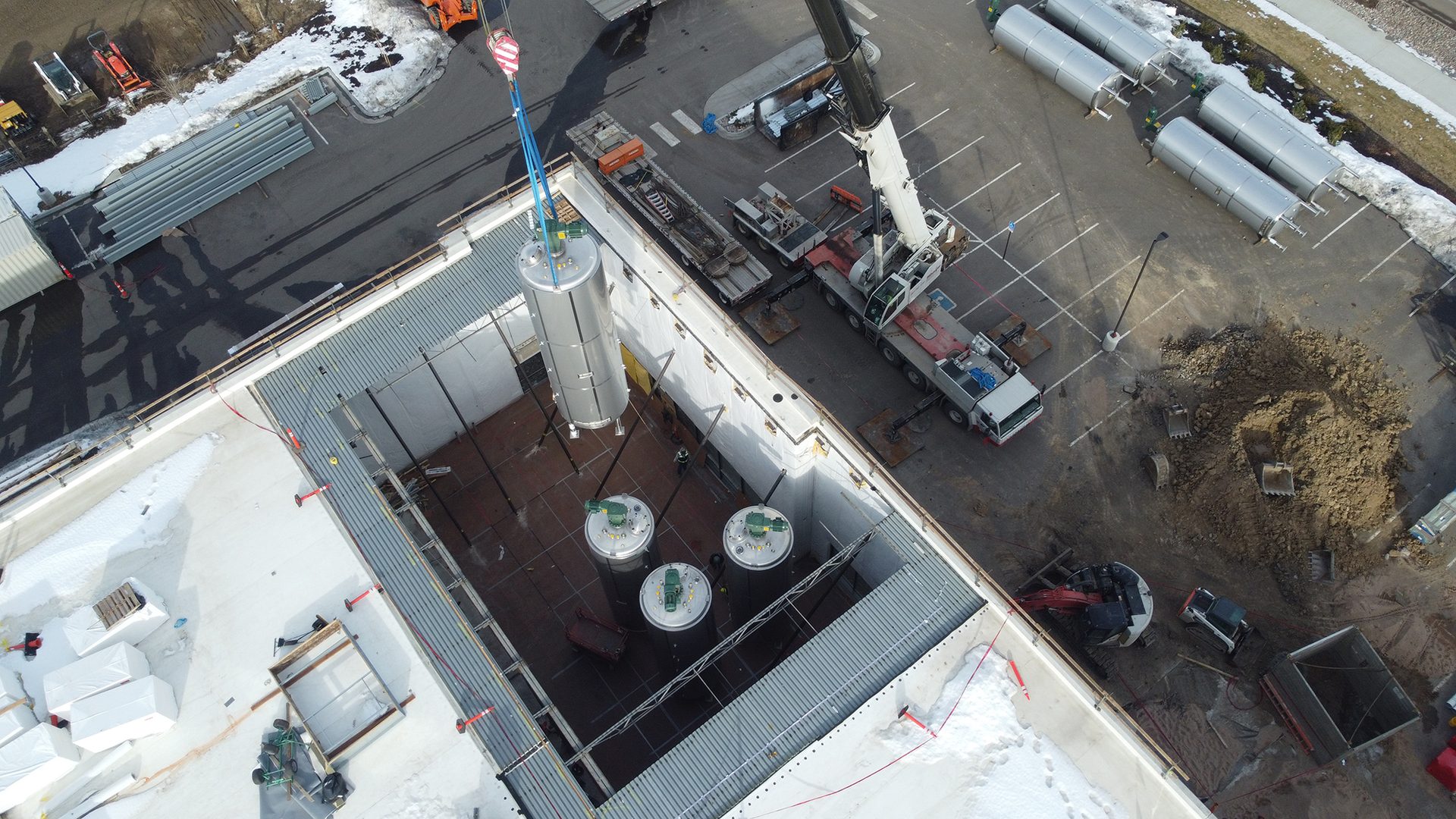 Transport hub, Urban design, Public space, Building, Car, Asphalt, VehicleA crane lowers a fermenter
