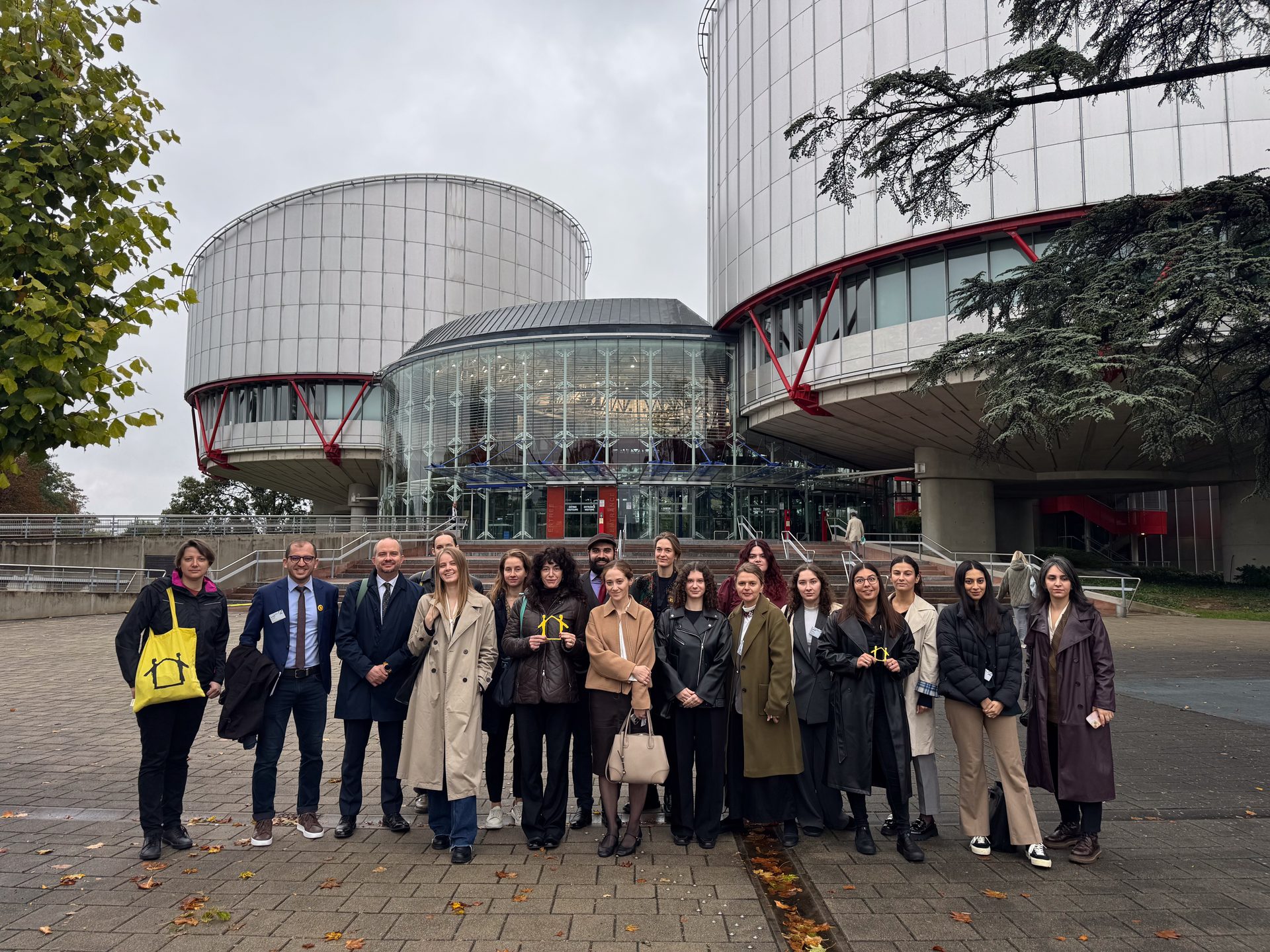 Group of people posing in front of the European Court of Human Rights building in Strasbourg.