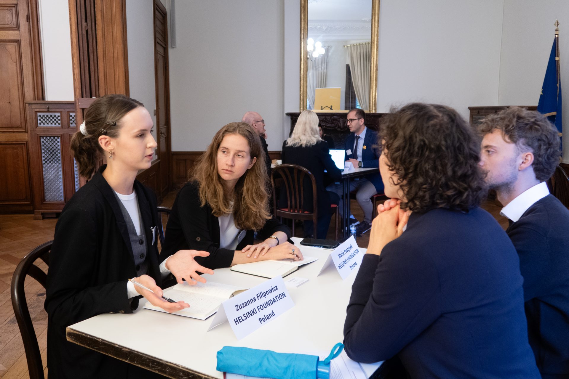 Members of the Helsinki Foundation Poland engage in a discussion at a meeting table.