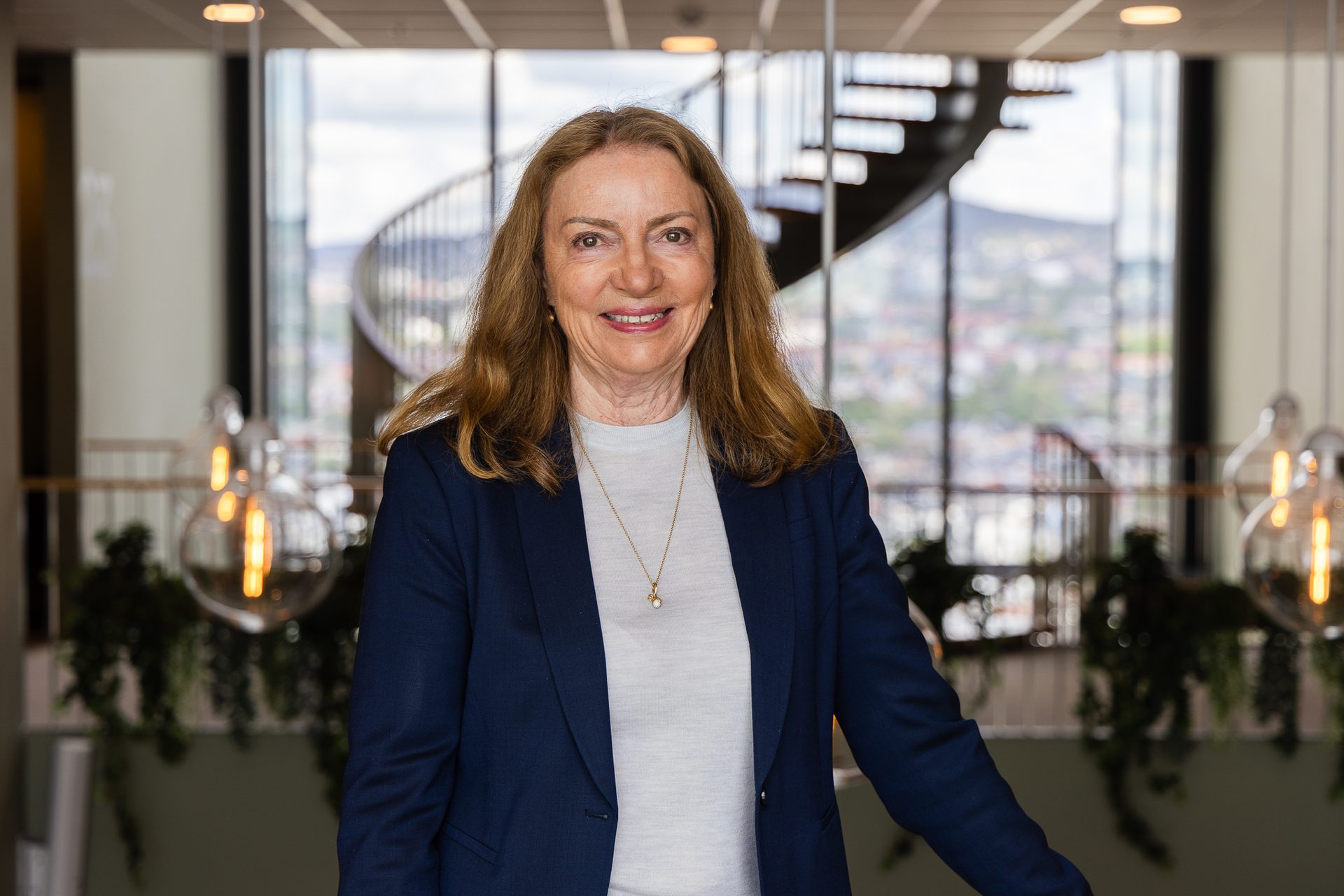 Smilende Solfrid Skilbrigt i blå dress i lokalene til Sopra Steria.