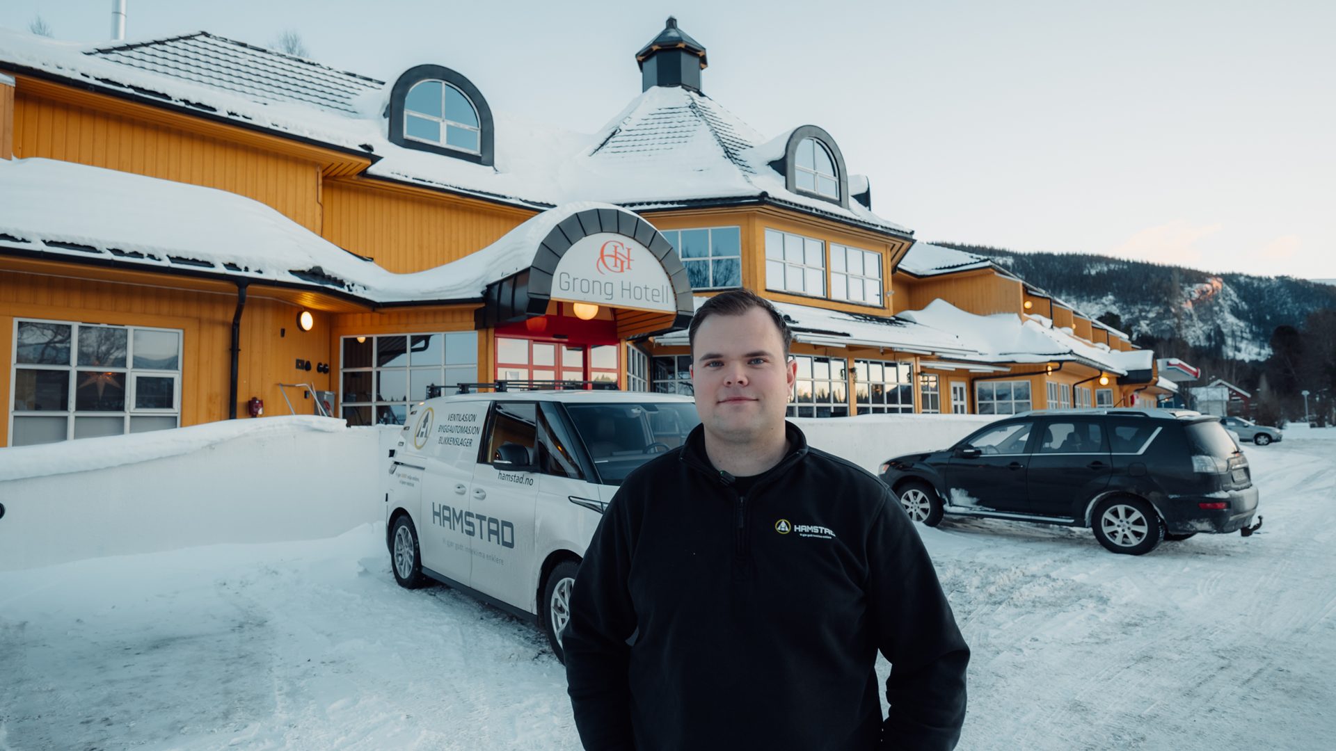 Man by Hamstad van and Grong Hotell in snowy mountains.