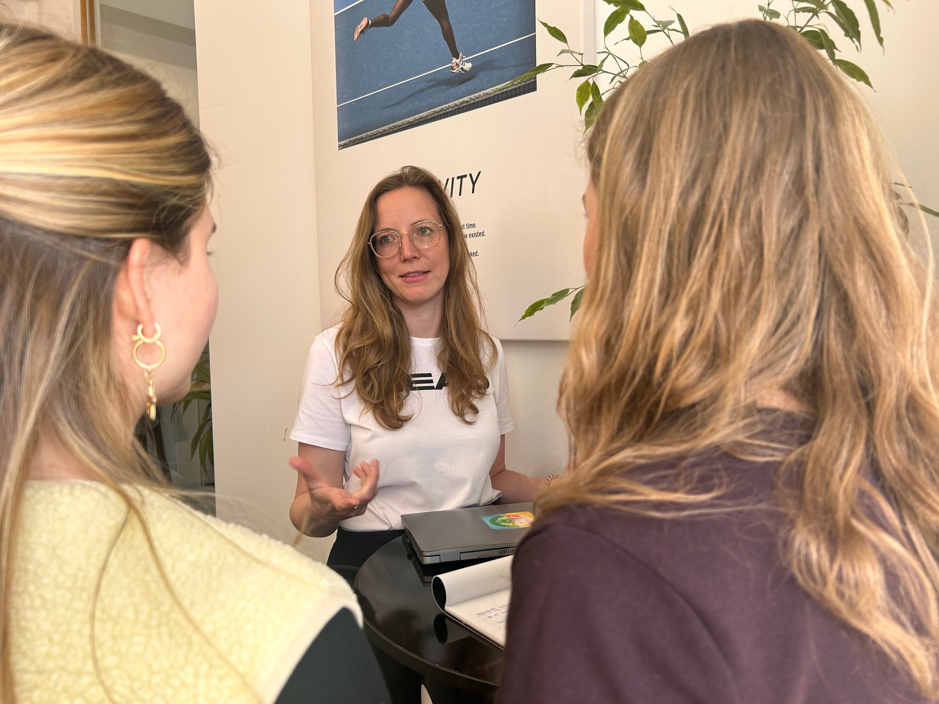 Three women in conversation, with one speaking and two listening.