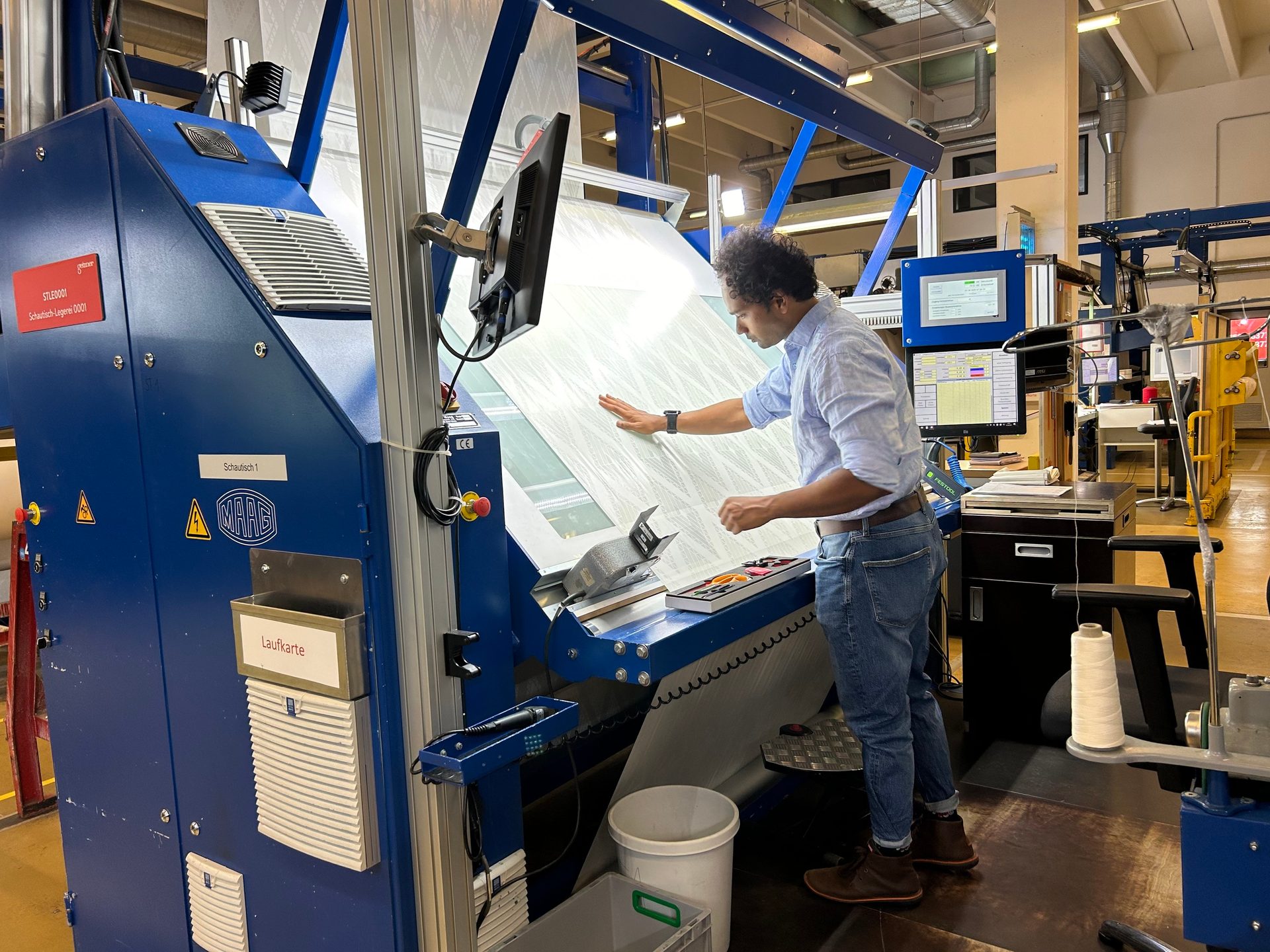 Ankur Jaiswal bei der Qualitätskontrolle eines Stoffes bei Getzner Textil.