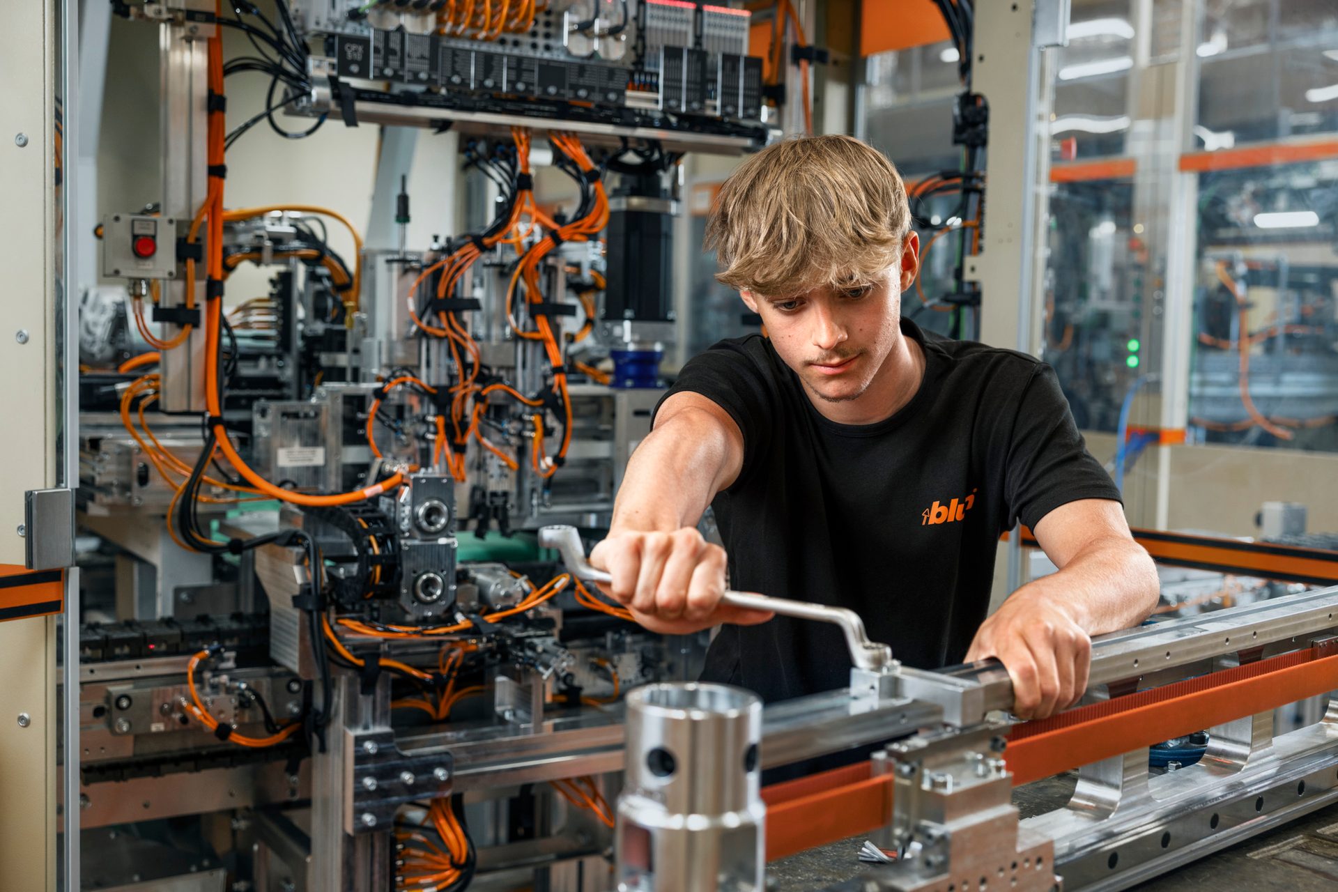 Man with wrench assembling complex industrial machinery.