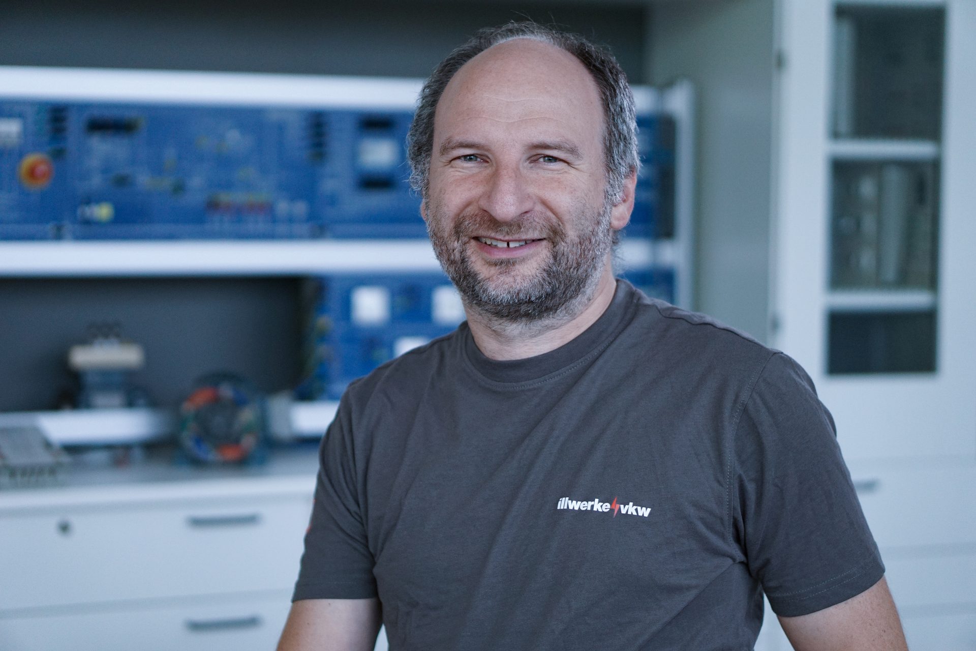 Portrait of a smiling bearded man in an "illwerke vkw" t-shirt.