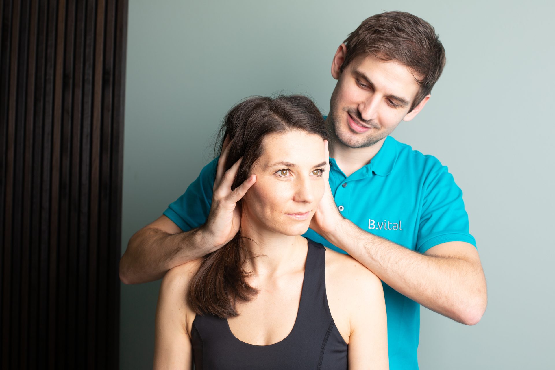 Therapist in blue shirt massaging a woman's head and neck.