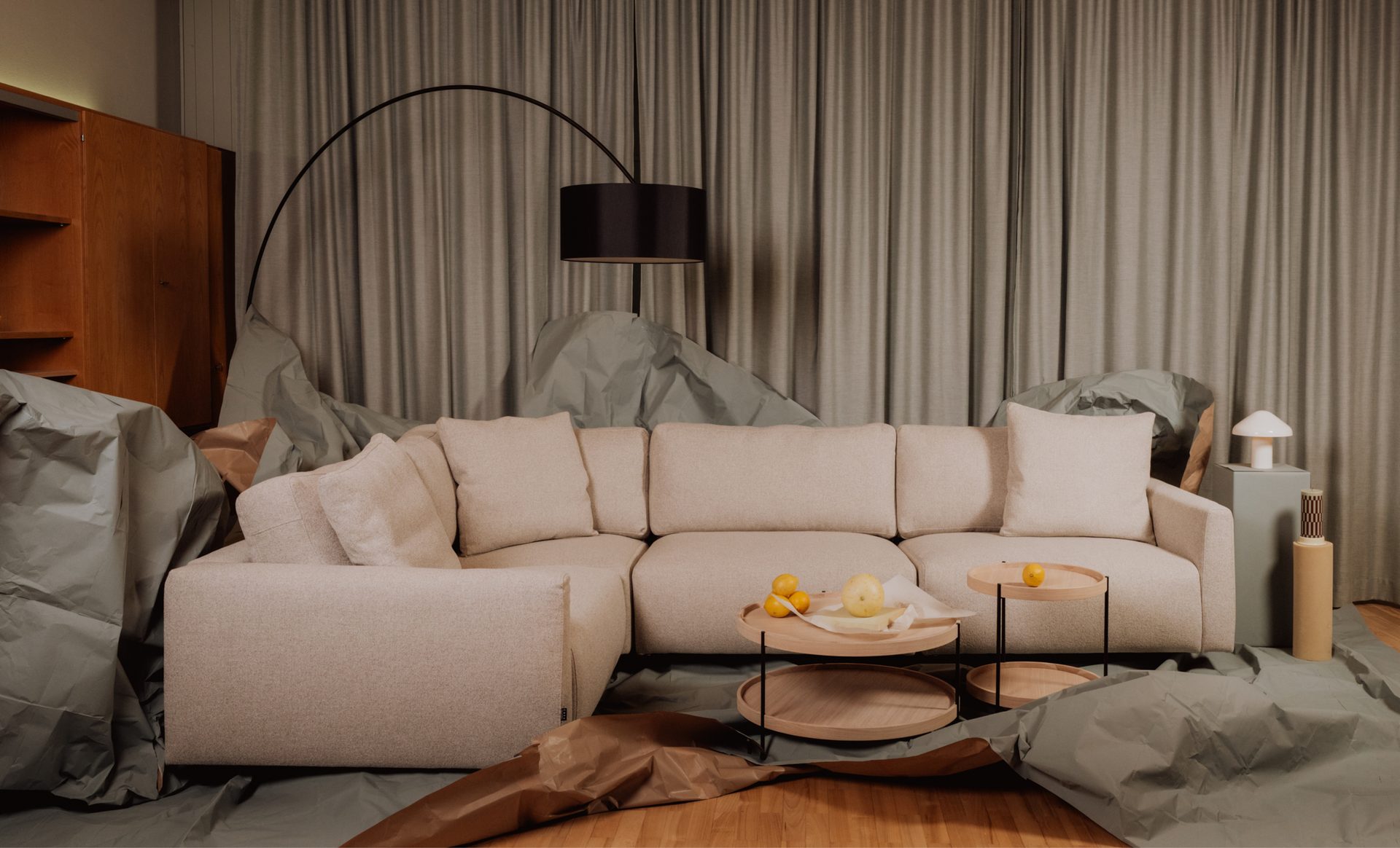 L-shaped sofa, coffee tables, arched floor lamp, and mushroom lamp in a modern living room.