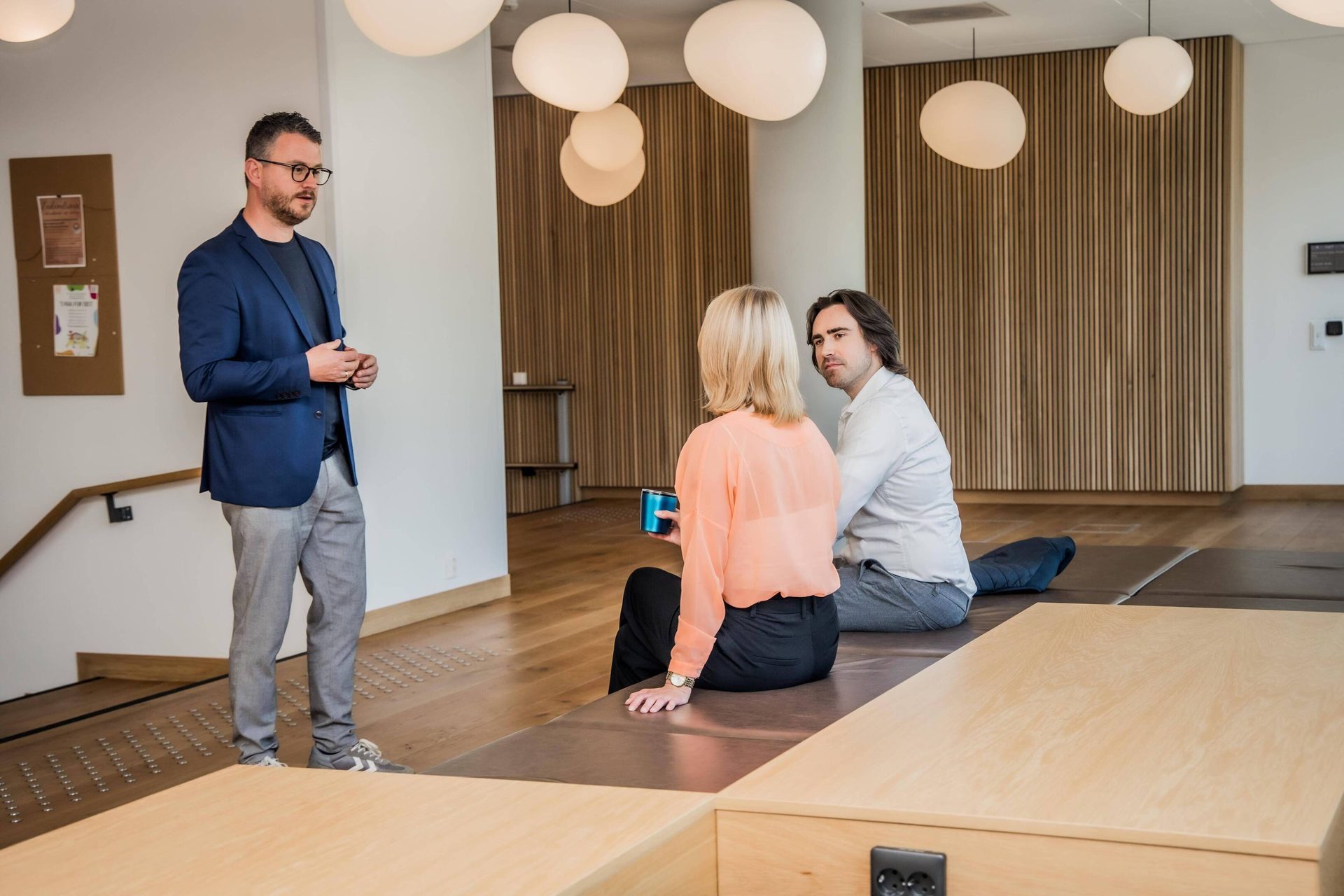 Interior design, Wood flooring, White-collar worker, Floor, Trousers, Standing, Furniture, Room
