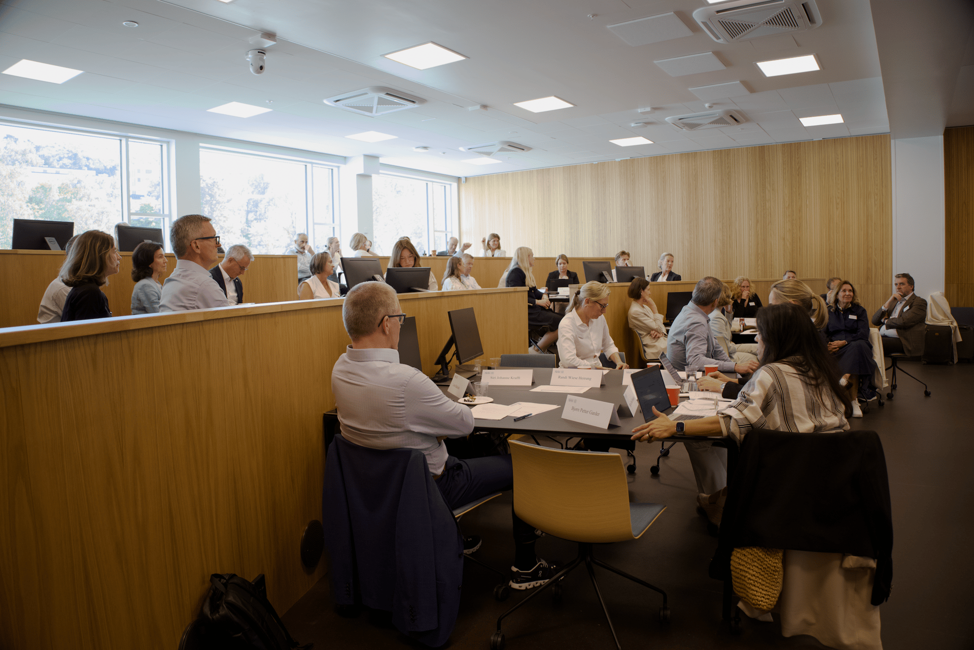 A large group of people attending a conference or meeting in a bright, modern room.