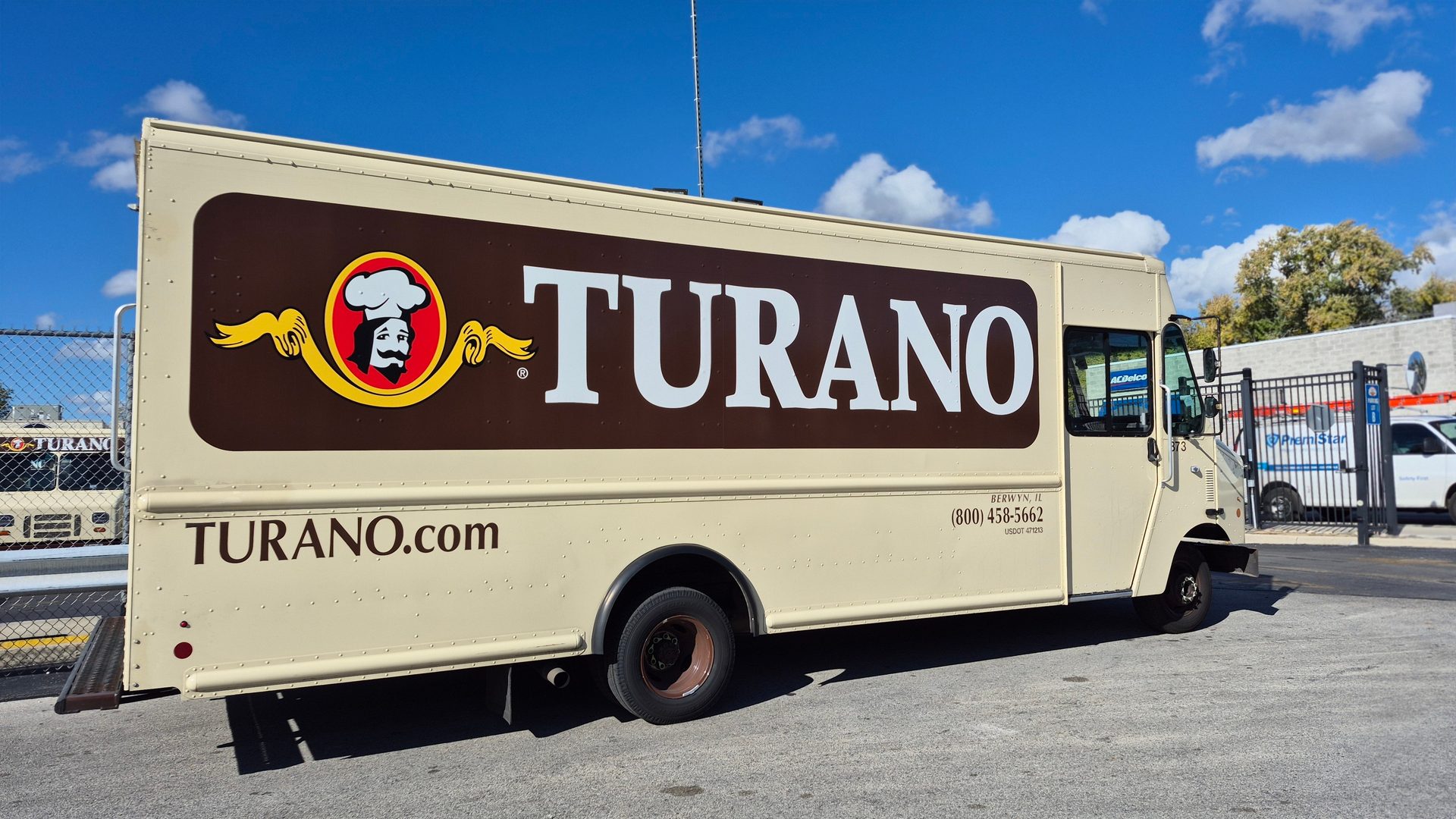 Cream delivery truck with "TURANO" logo, baker illustration, "TURANO.com", contact info.