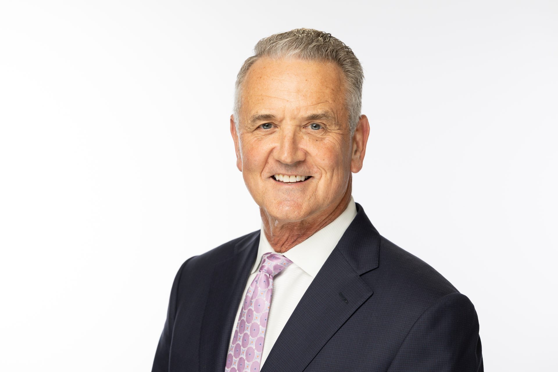 Person wearing suit and tie smiling