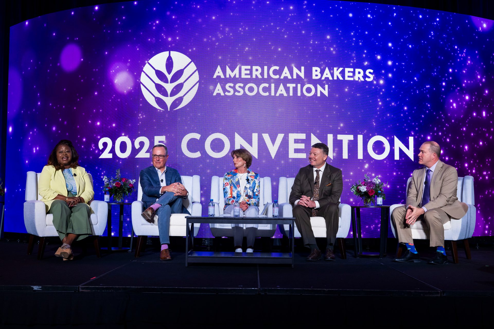 Five people sit on a stage in front of a screen displaying "American Bakers Association 2025 Convention."