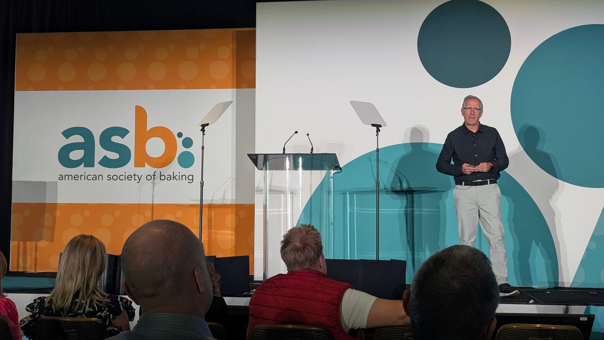 Speaker at American Society of Baking event addressing an audience.