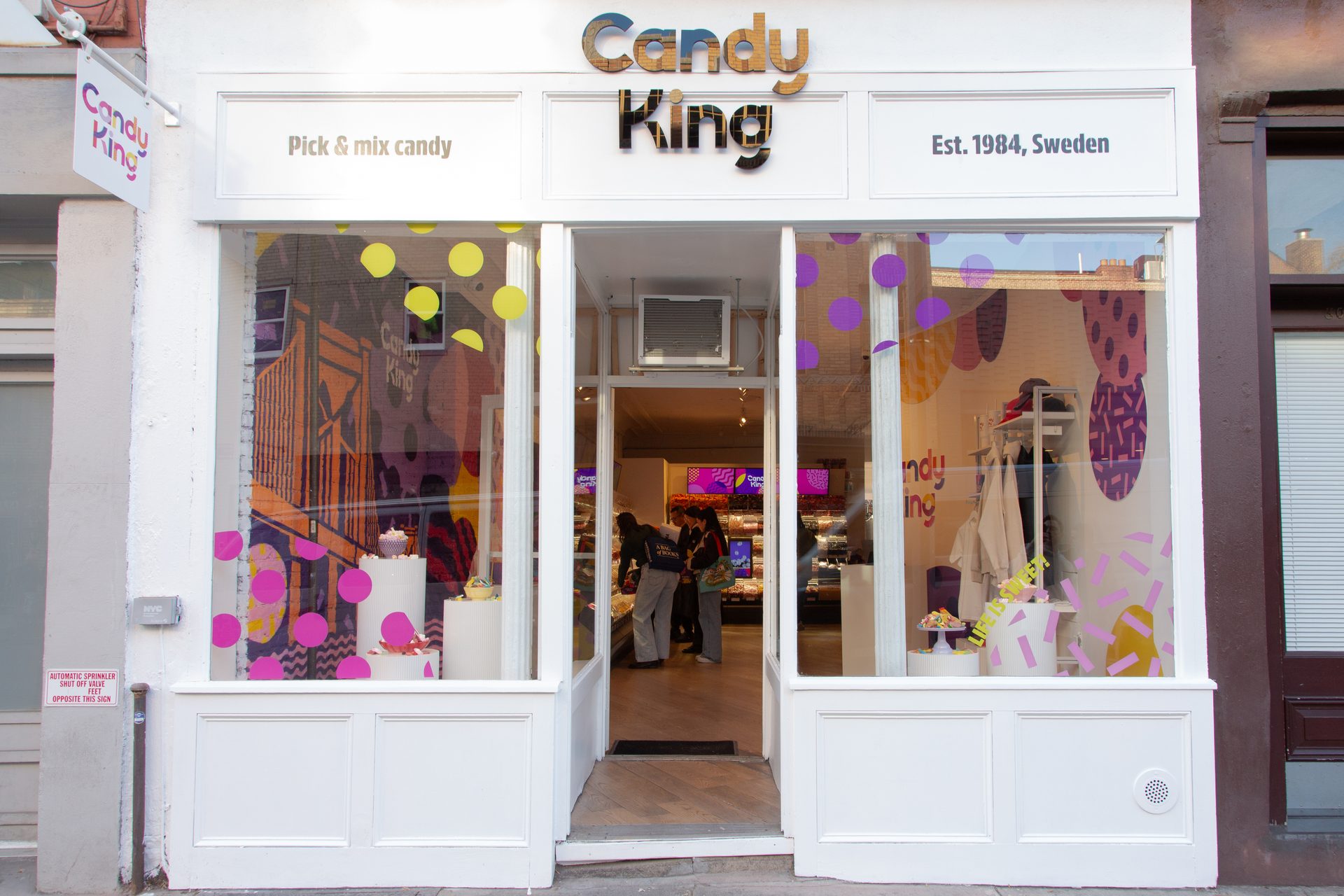 Exterior view of Candy King, a pick & mix candy store established in Sweden in 1984, with colorful window displays.