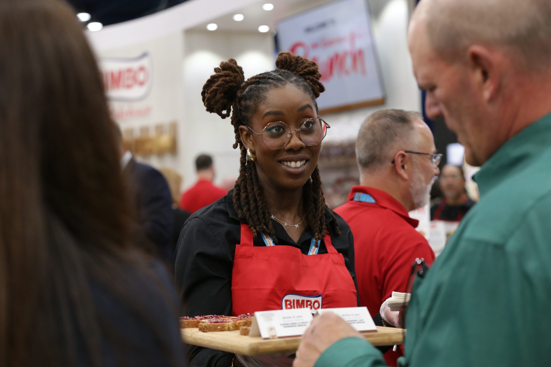 A woman representing Bimbo Bakeries offers samples to IDDBA attendees