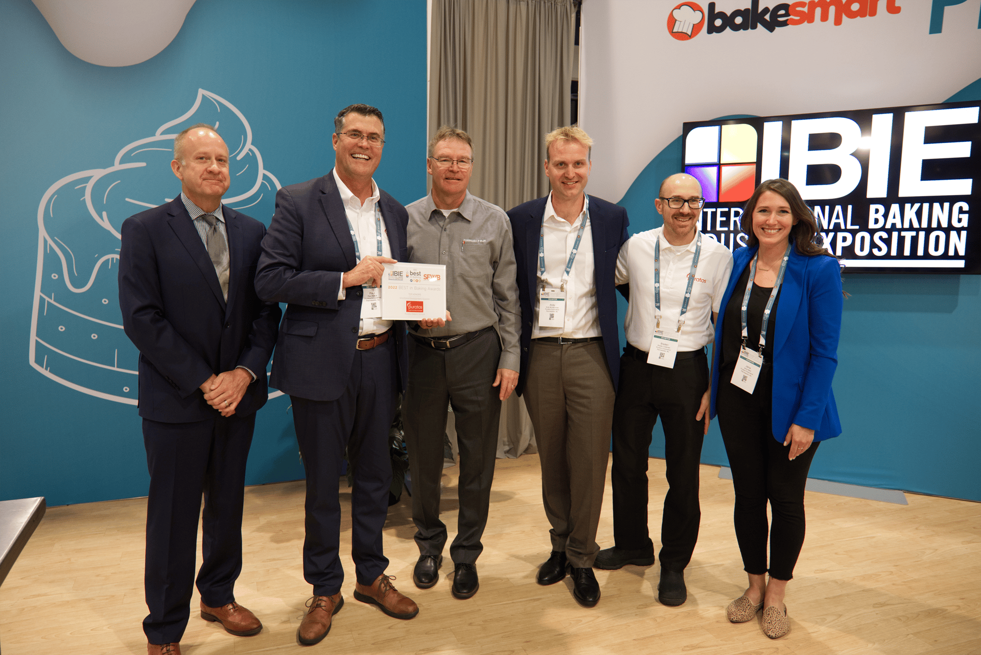 Six people standing with one man holding certificate