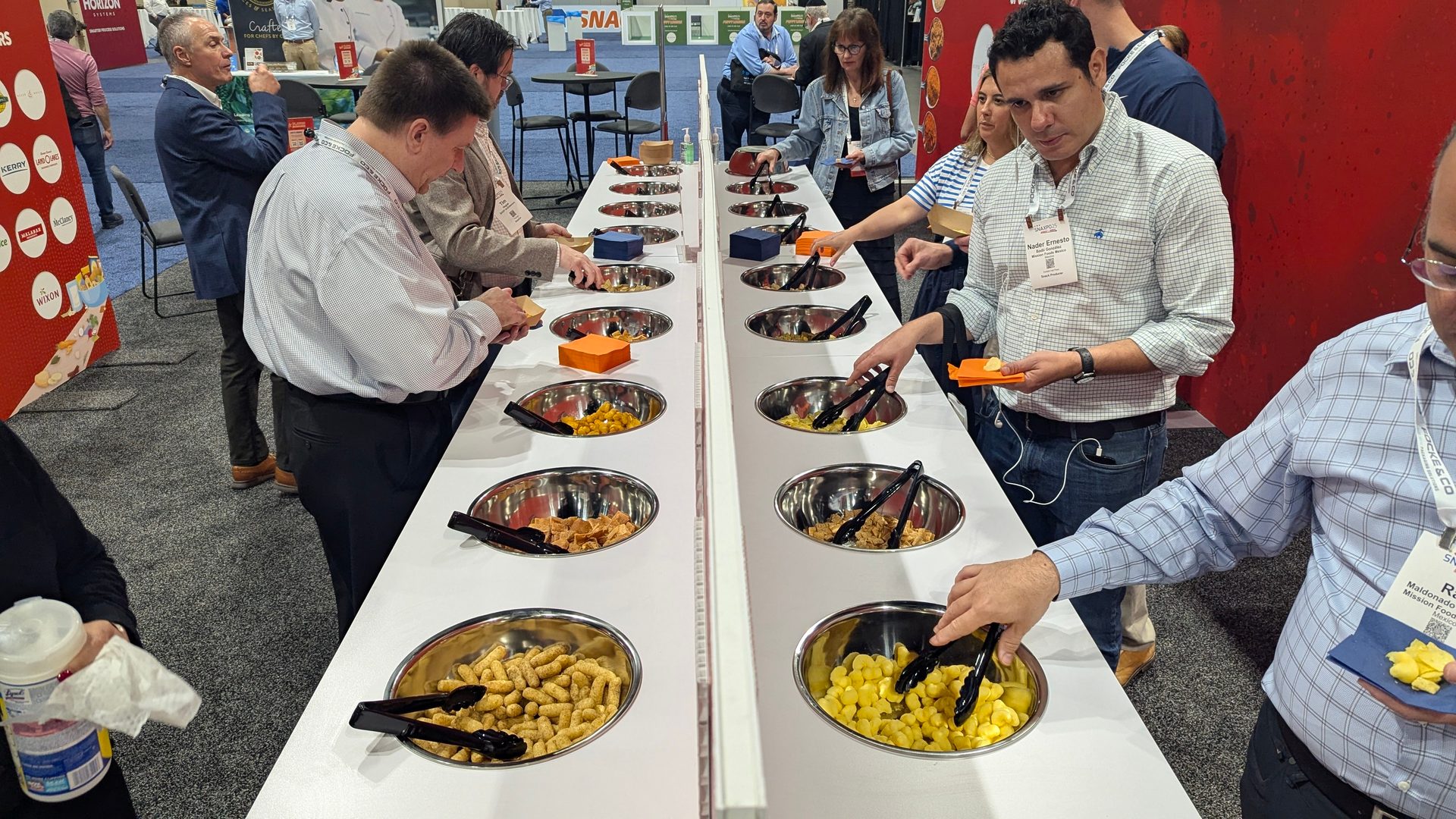 SNAXPO 2025 attendees sample puffed and extruded snacks, potato chips, and more