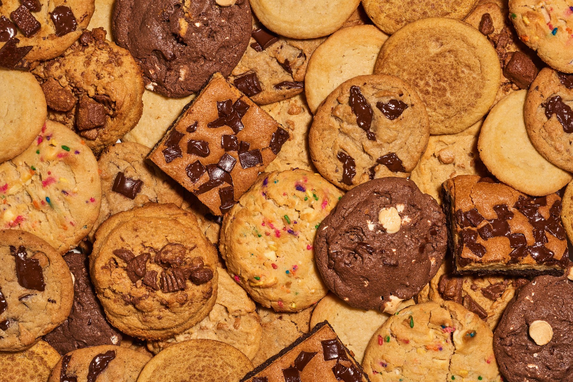 Assortment of cookies: chocolate chip, double chocolate, sprinkle, snickerdoodle, plus chocolate bars.