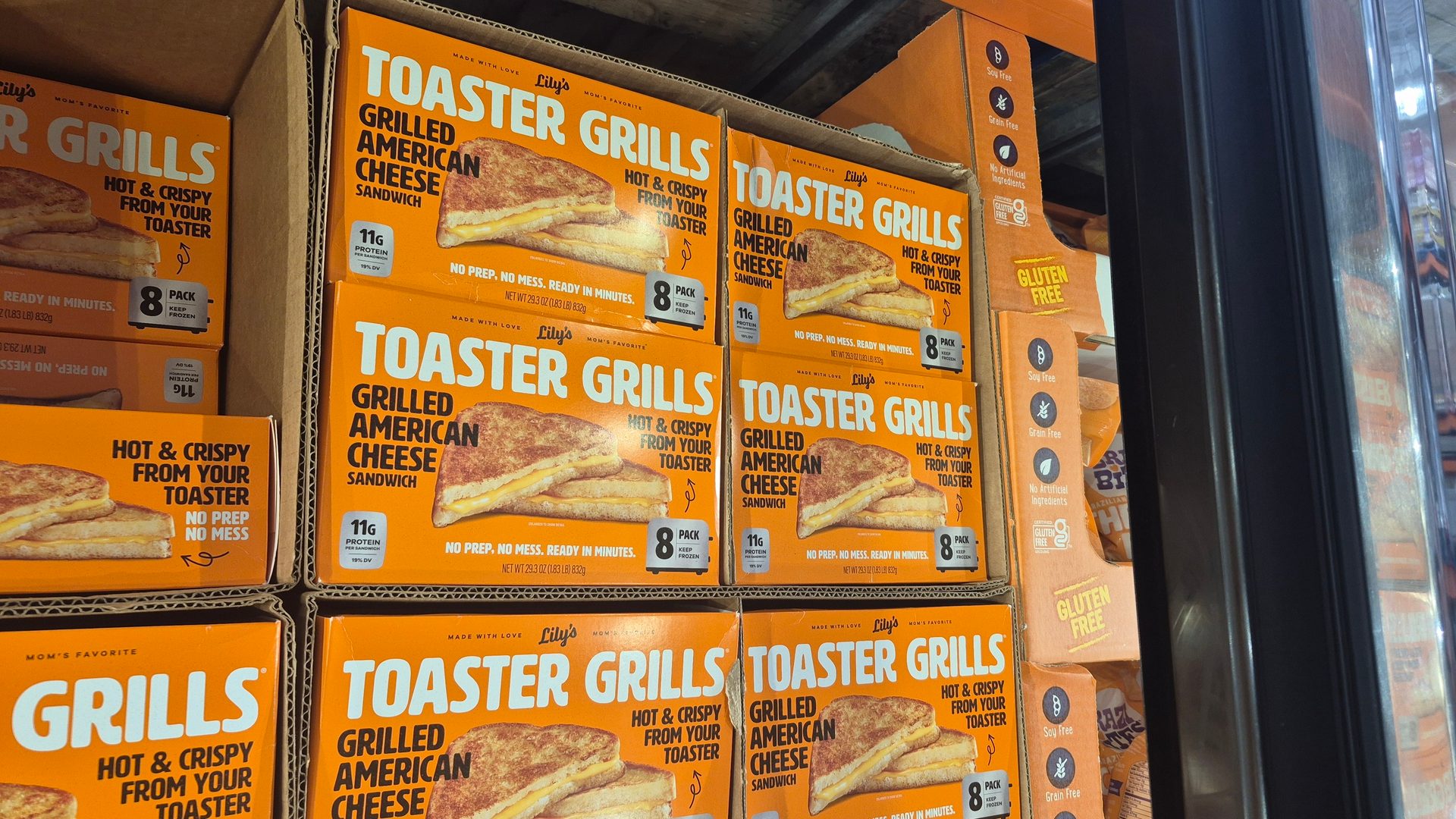 Boxes of Lily's Toaster Grills Grilled American Cheese Sandwiches in a freezer display.
