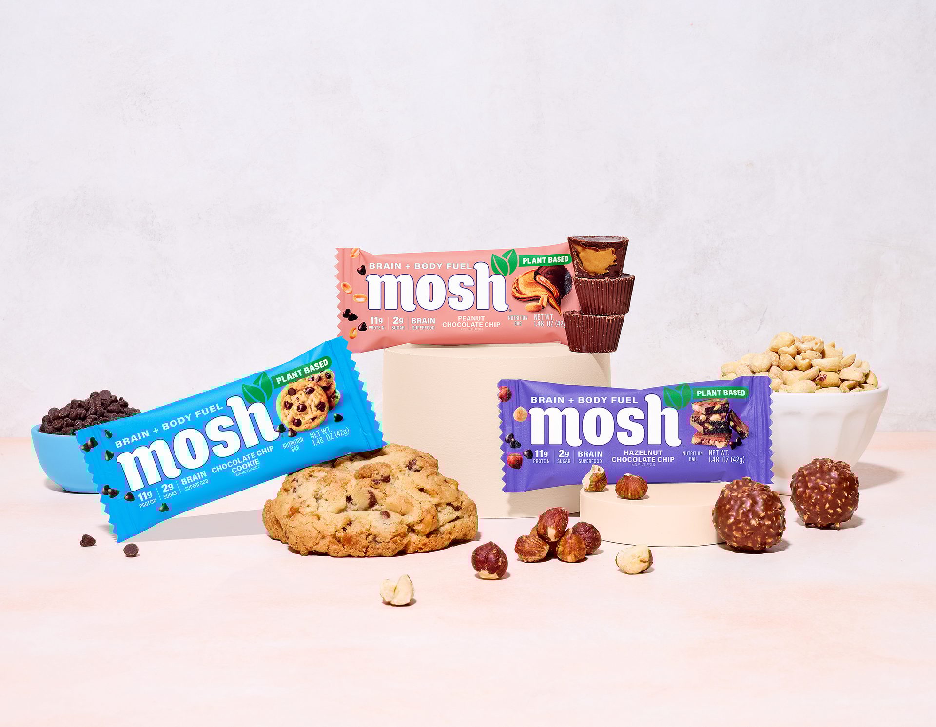 Trio of protein bars with a cookie, chocolate, and nuts around