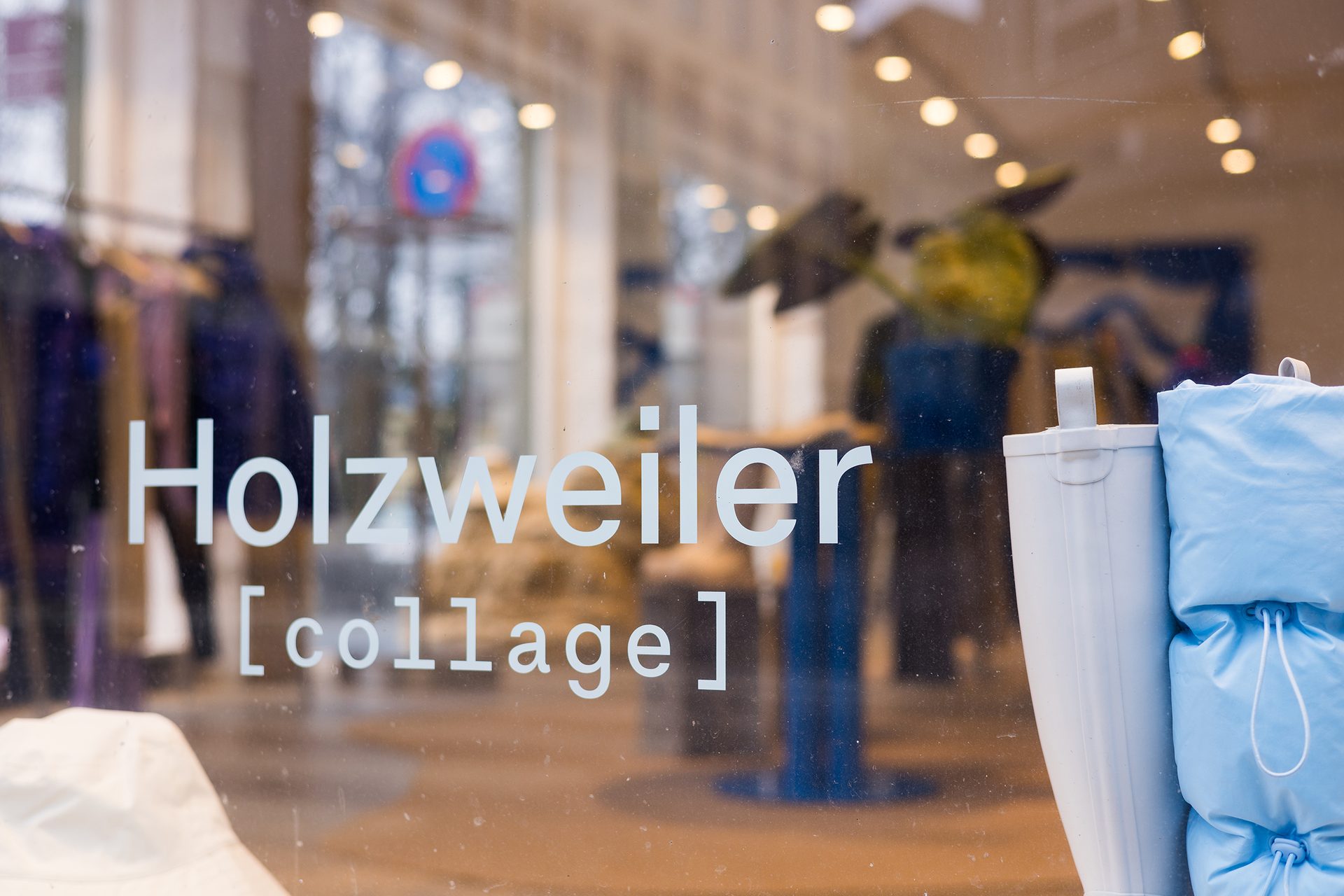 En klesbutikk sett gjennom butikkvinduet med Holzweiler-logo p&#xE5;.