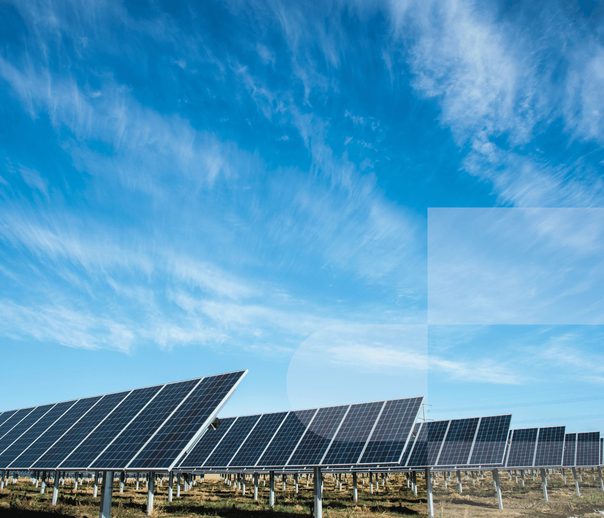 Rows of solar panels under a blue sky with clouds.