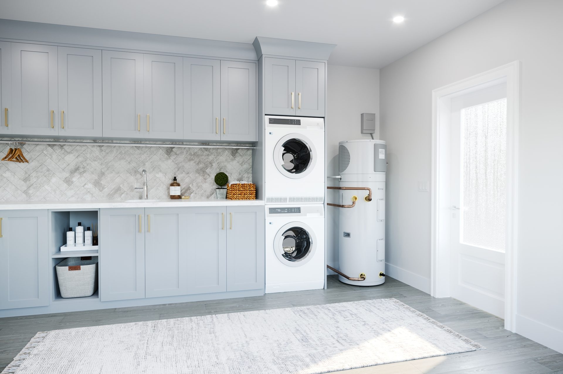 A bright laundry room with a stacked washer and dryer, light gray cabinets, sink, and water heater.
