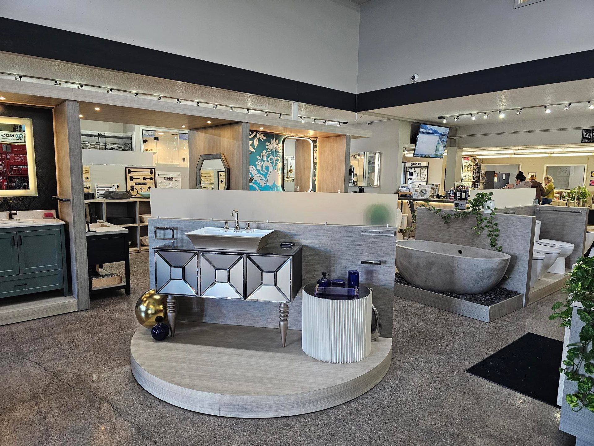 Bathroom showroom with various vanities, sinks, and a stone tub on display.