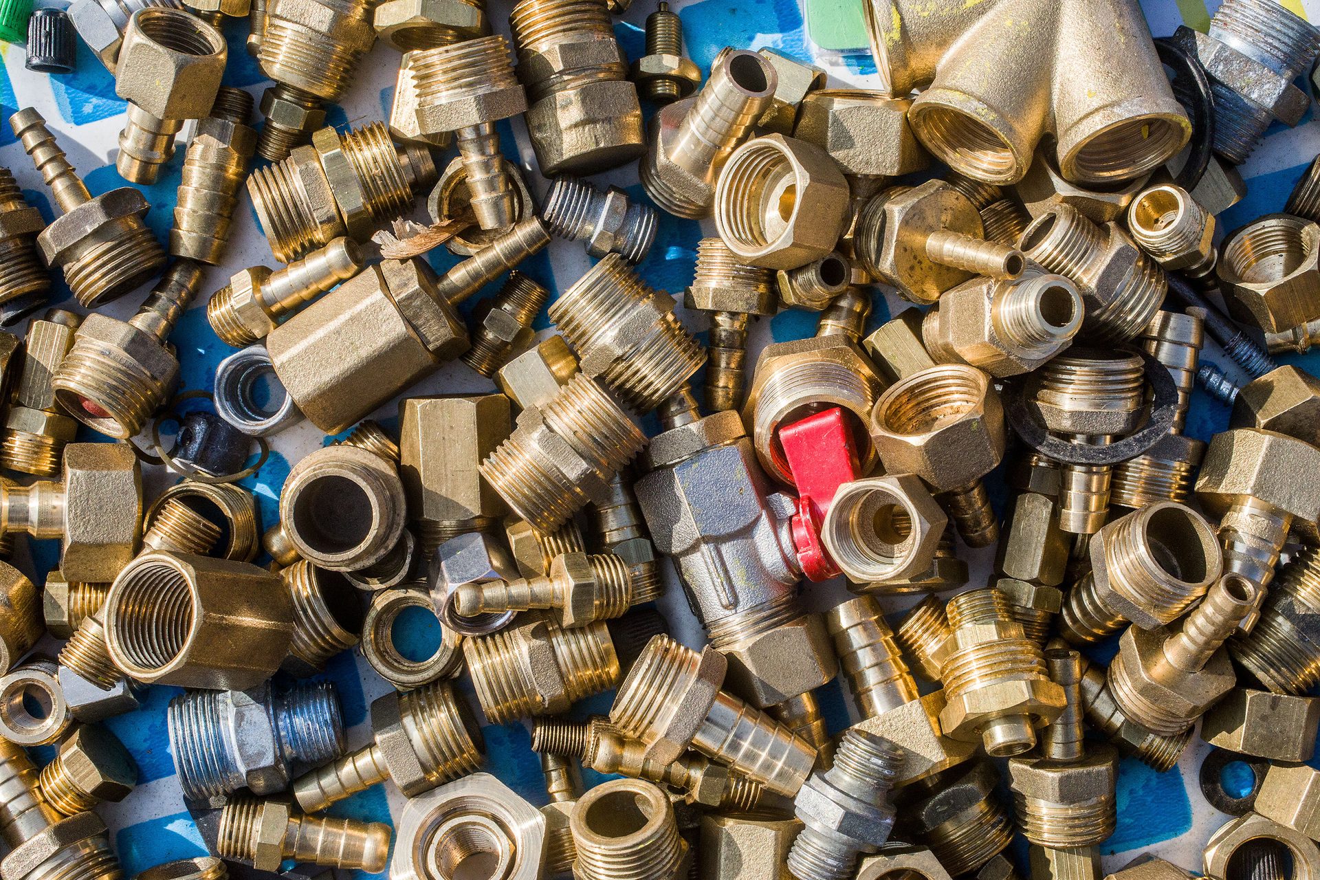 A pile of brass and silver plumbing fittings.