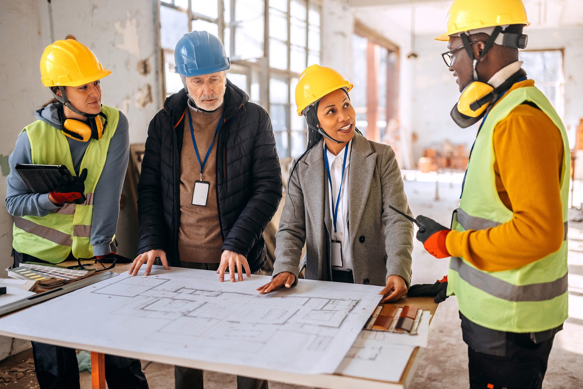 Diverse construction team discussing blueprints on a job site.