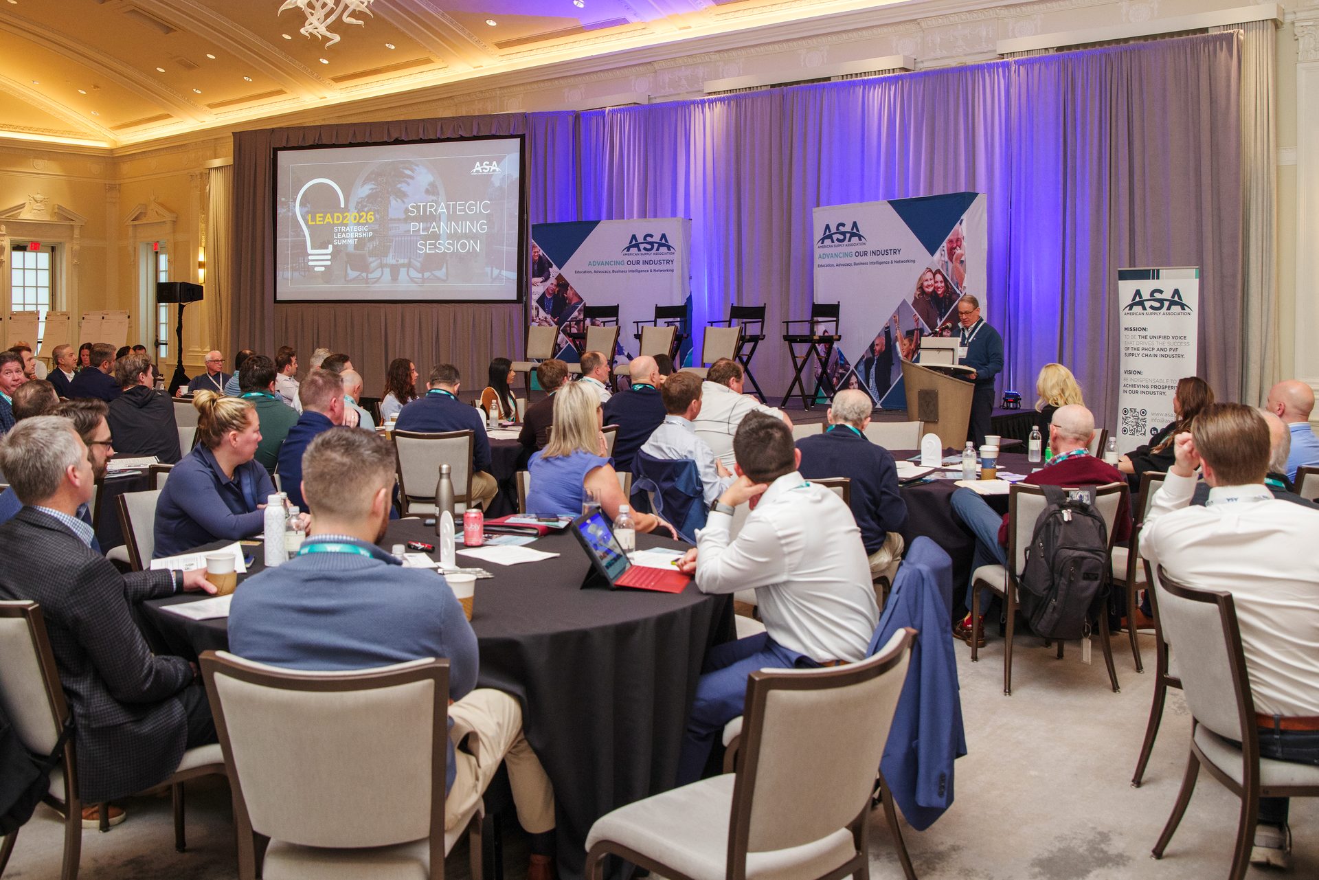 People attending a 'Strategic Planning Session' at an ASA conference, with a speaker and presentation screen.