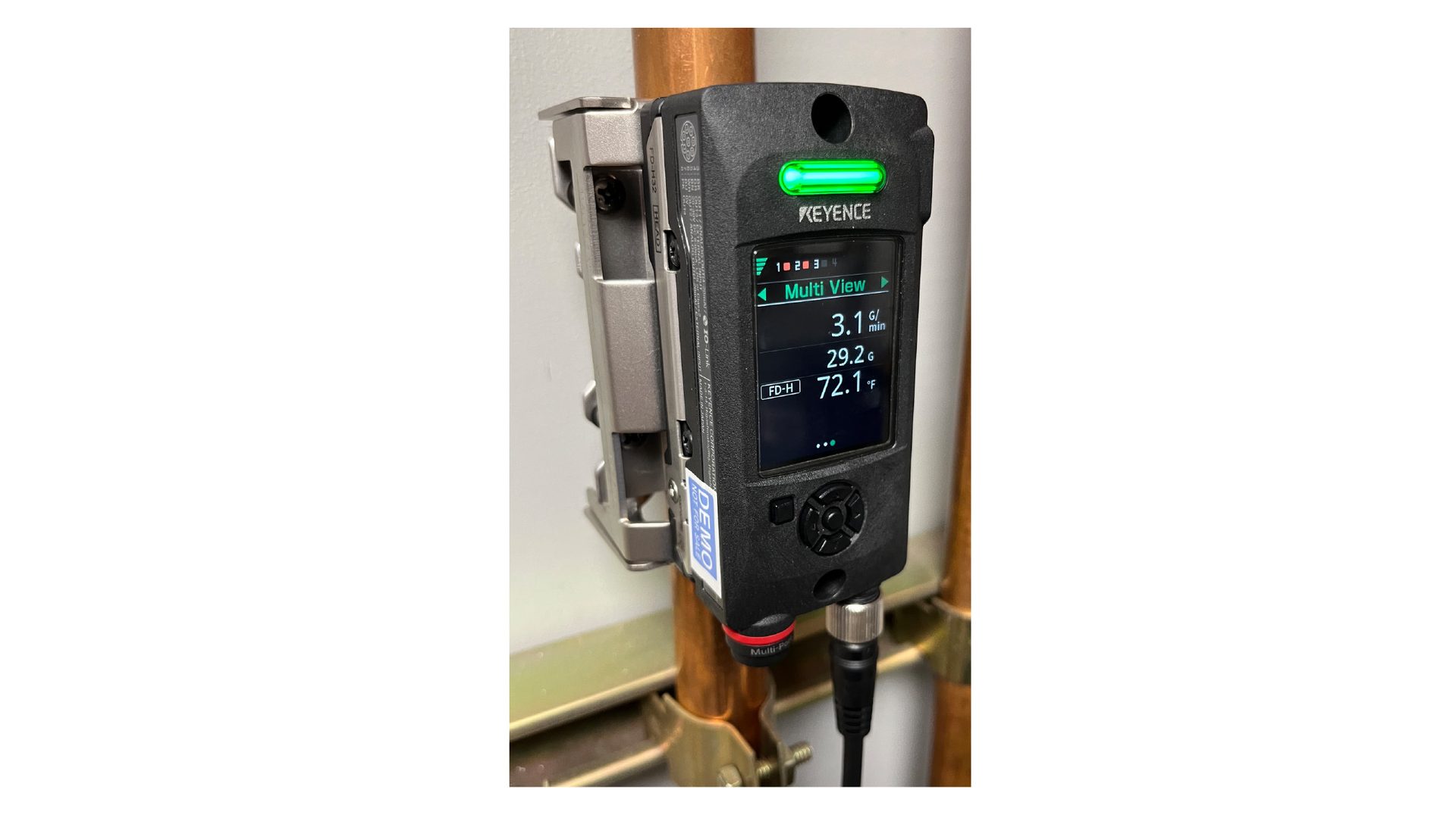 Keyence flow sensor on pipe, showing 3.1 G/min, 29.2 G, and 72.1 °F.