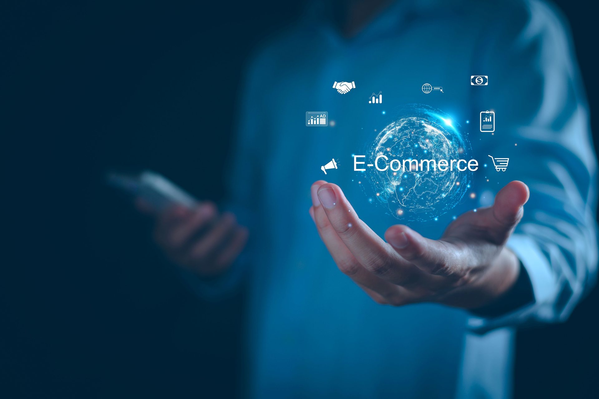A hand holds a glowing digital globe with "E-Commerce" text and business icons against a blue background.