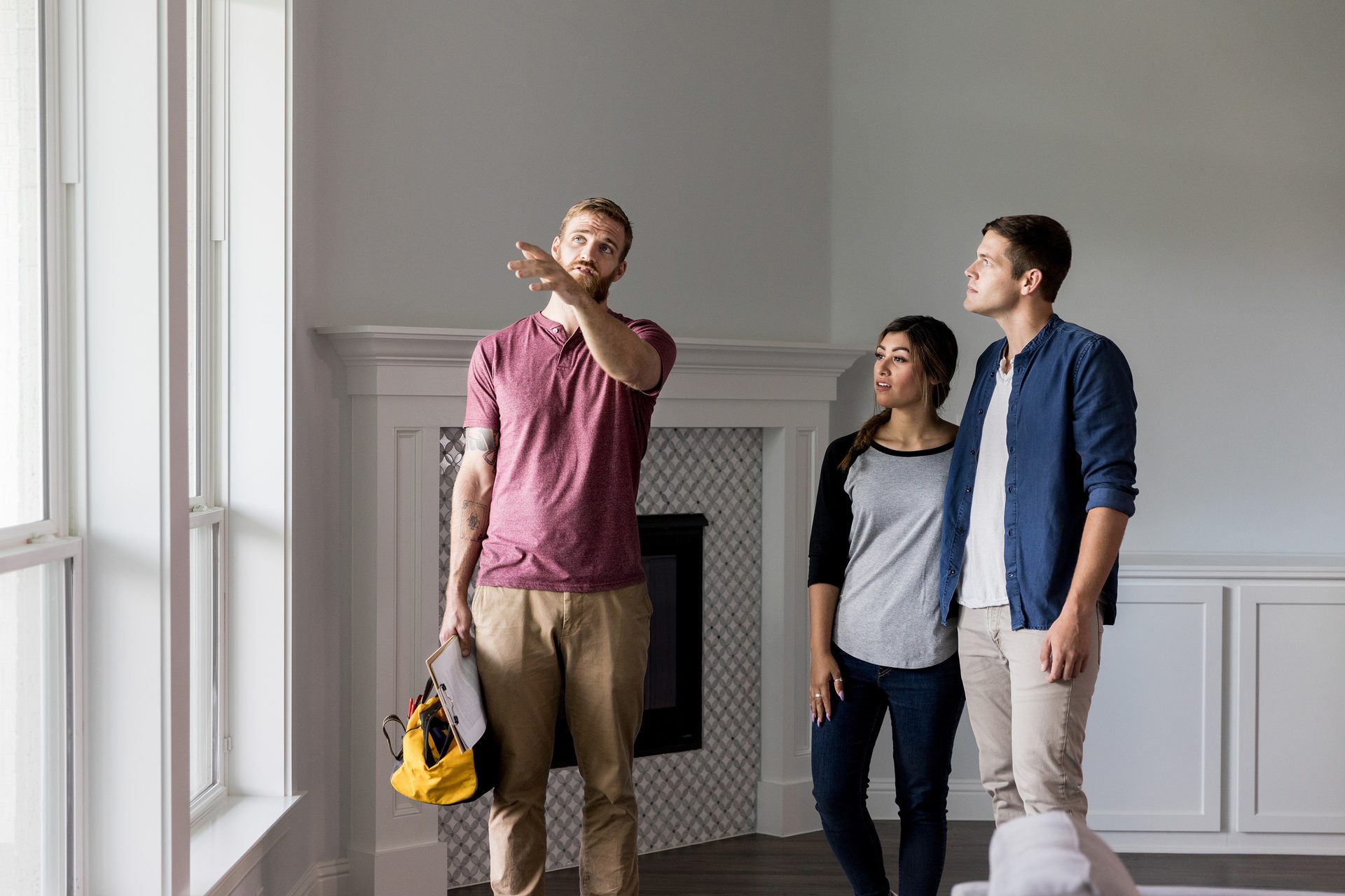 A contractor explains details to a couple during a home inspection or property tour.