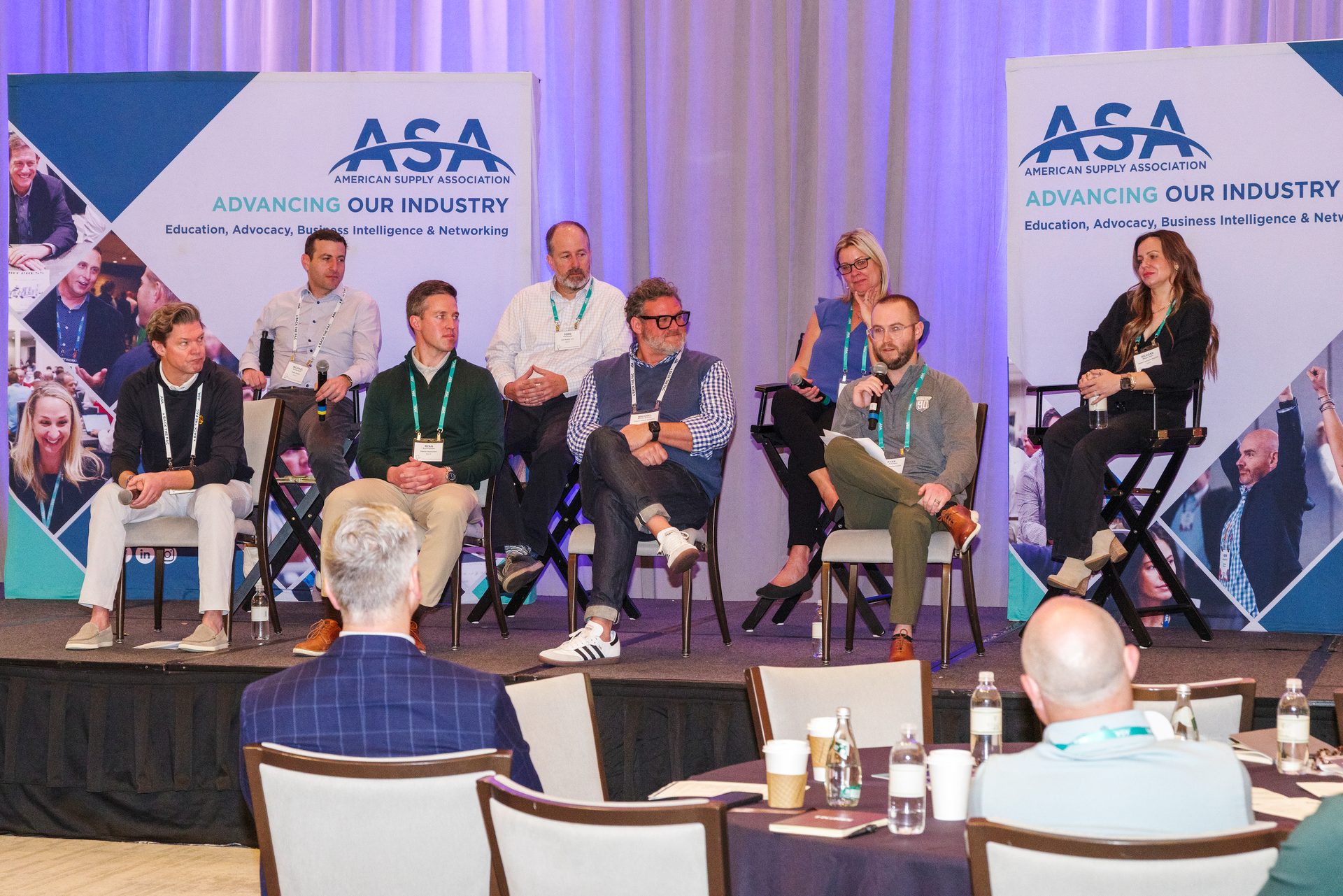 Panel discussion with eight people on stage at an American Supply Association event.
