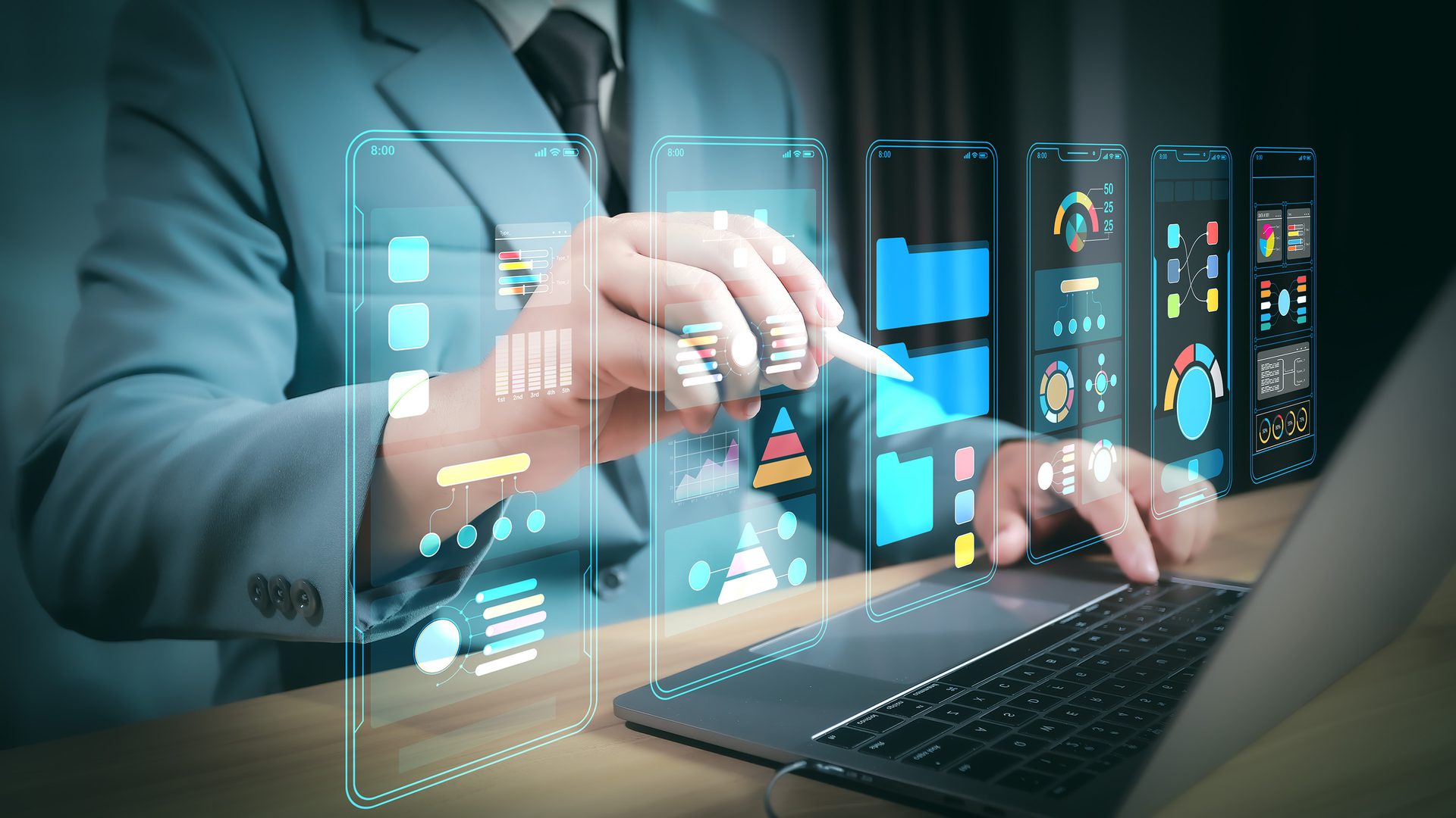Man in suit uses laptop, touching holographic data screens with charts and graphs.