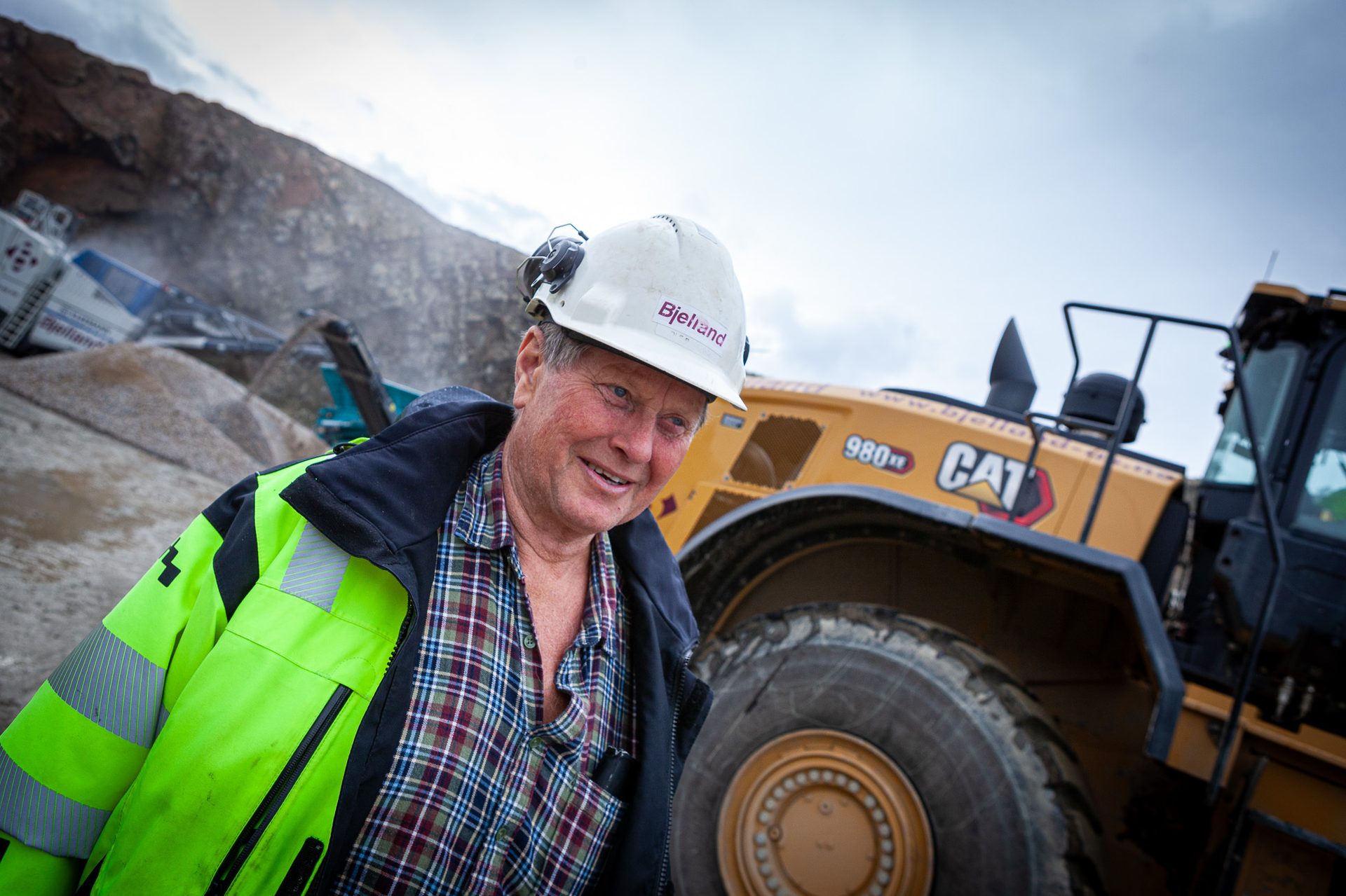 Hard hat, Automotive tire, Sky, Wheel, Smile, Helmet, Vehicle, Workwear, Cloud