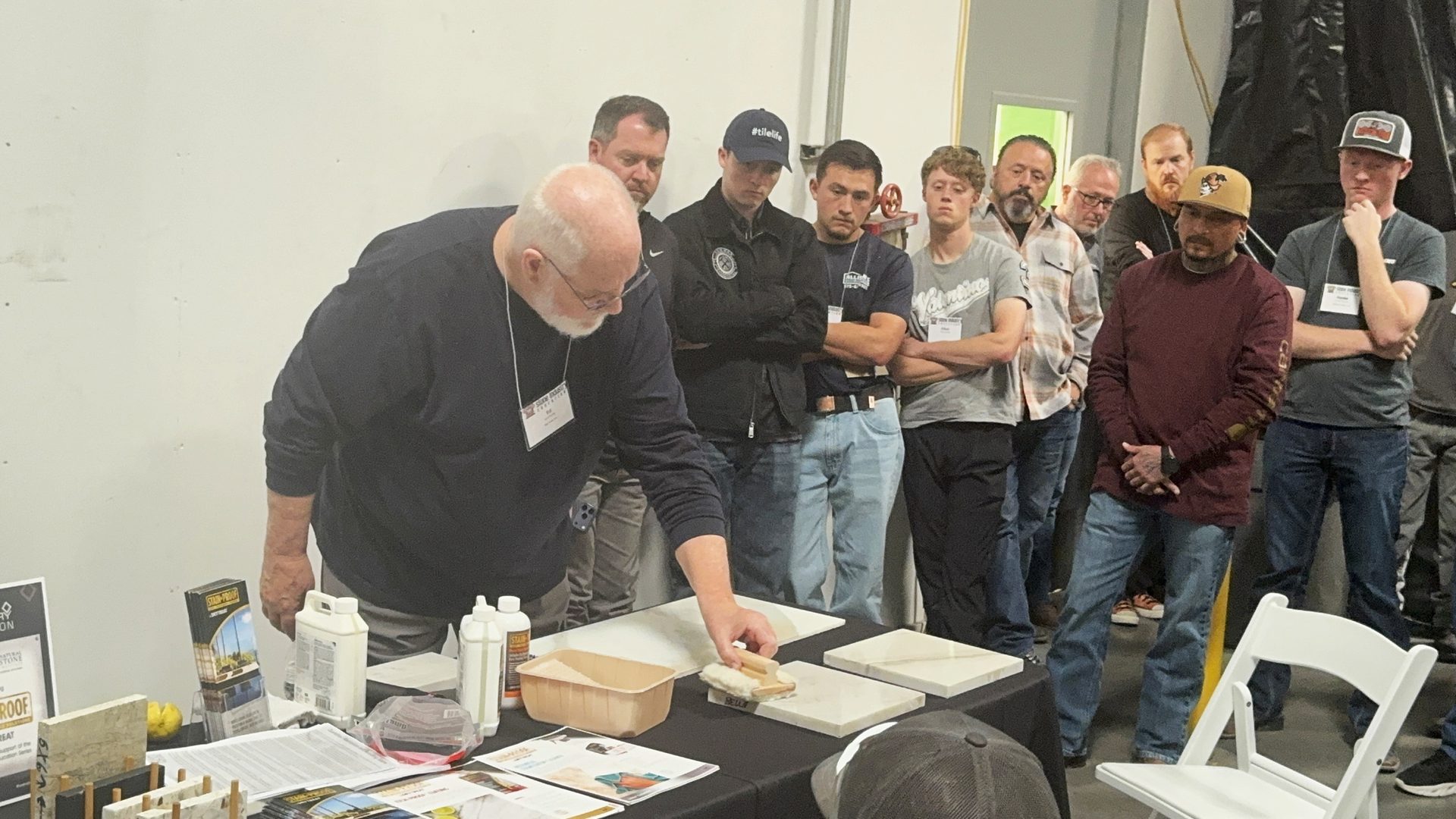 Group of individuals watching a demonstration on the proper way to seal quartzite