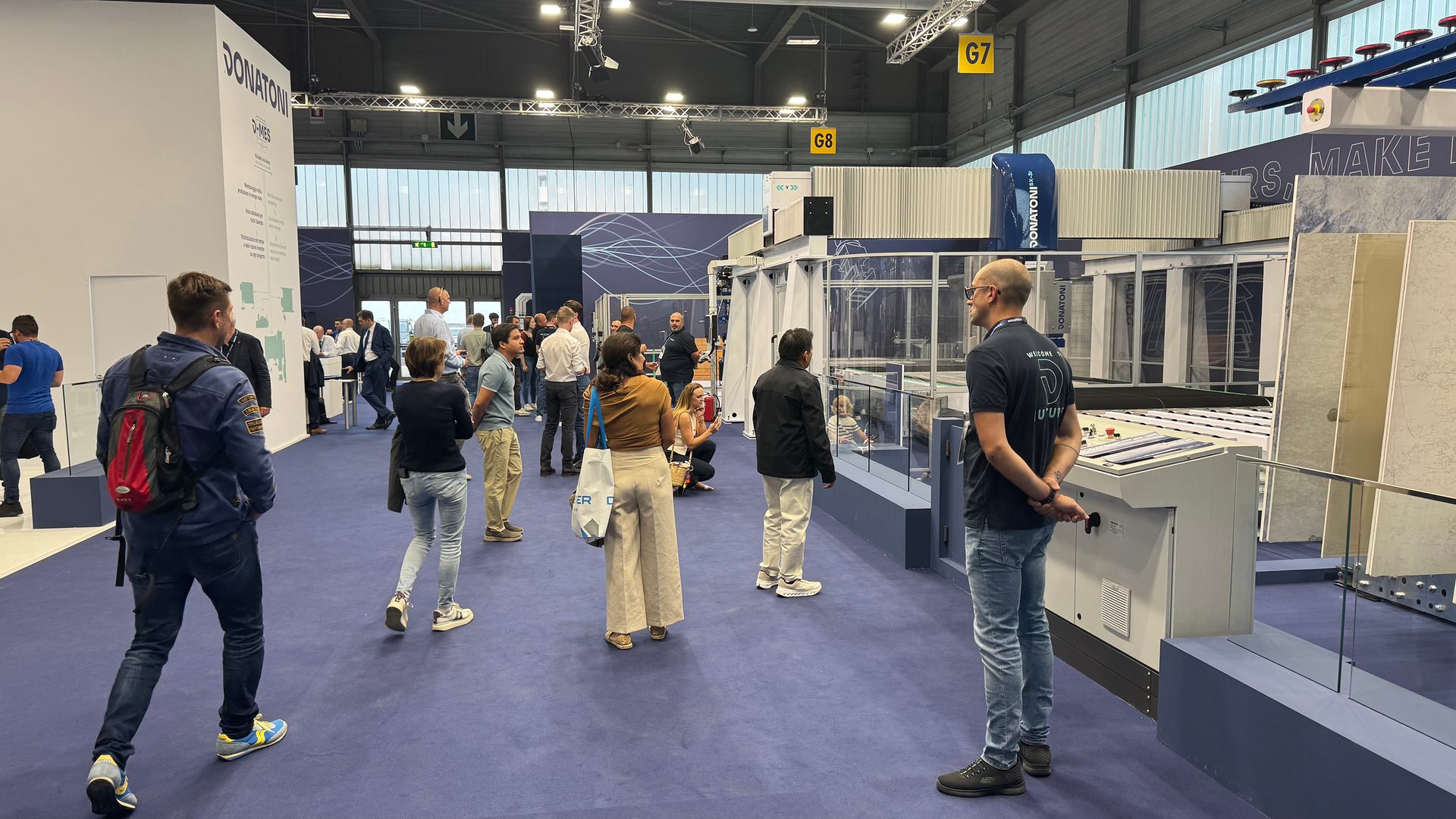 Visitors examining Donatoni industrial machinery at an exhibition.