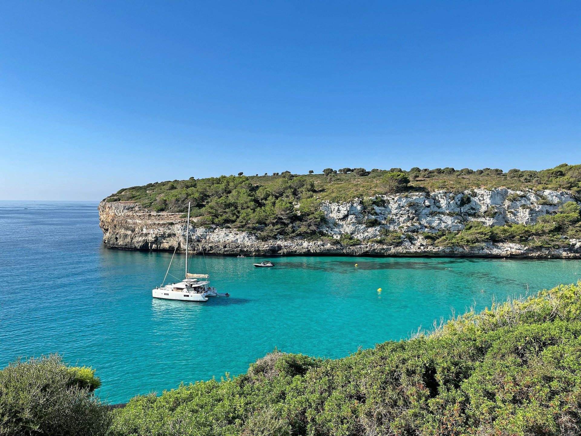 Coastal and oceanic landforms, Body of water, Blue, Coast, Rock, Headland, Boat, Watercraft