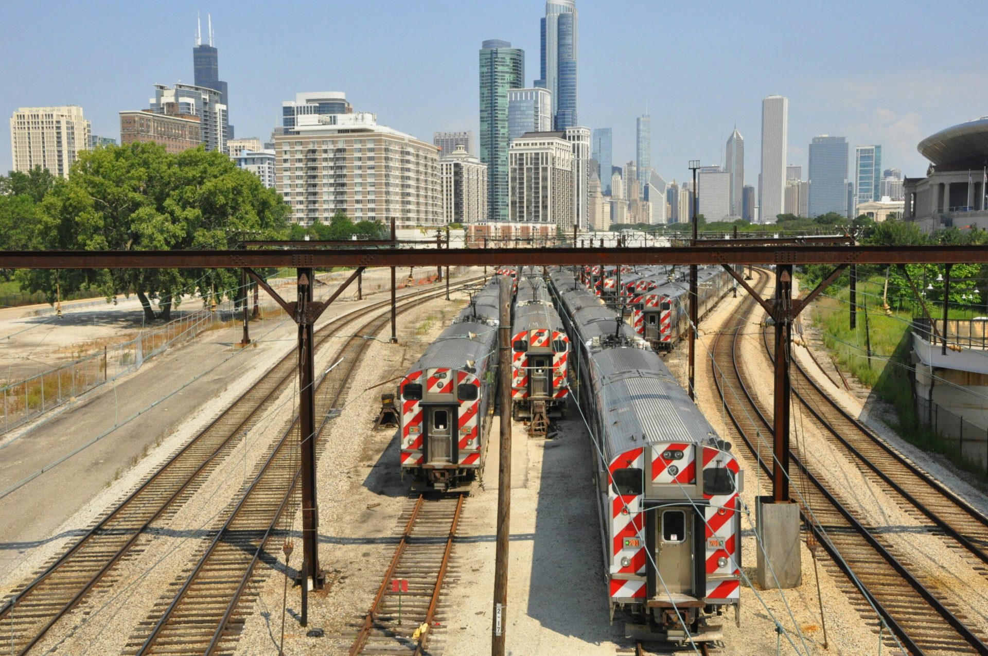 Metra trains on tracks with Chicago skyline in background.
