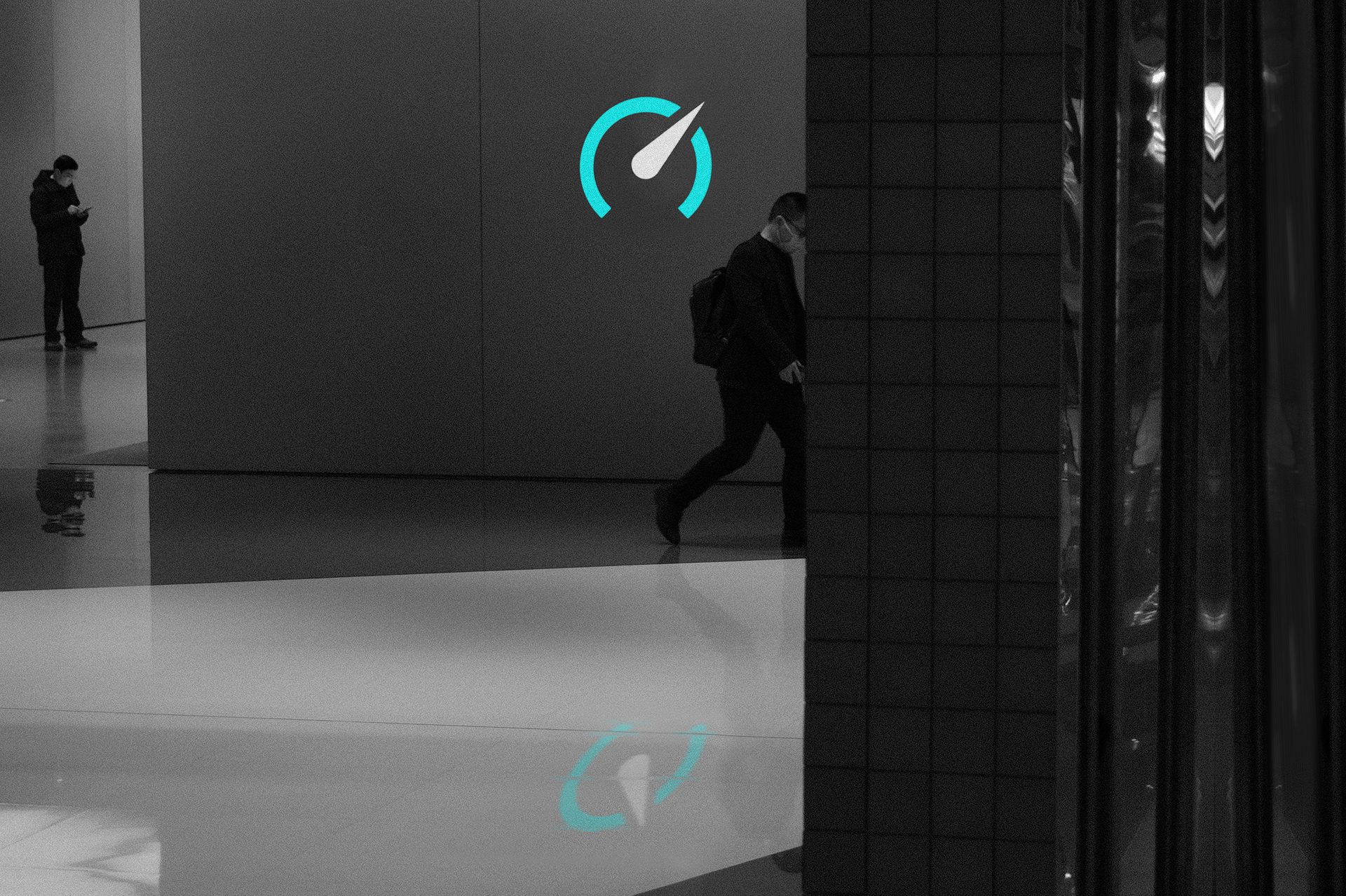 Grayscale indoor scene with two men, a glowing blue gauge icon, and its reflection on a polished floor.