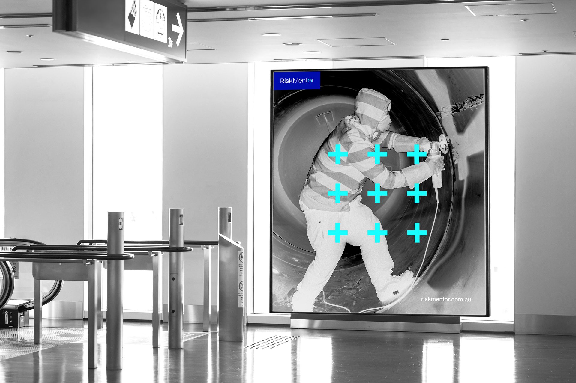 Digital display showing person with power tool & blue crosses in a public hall with turnstiles.