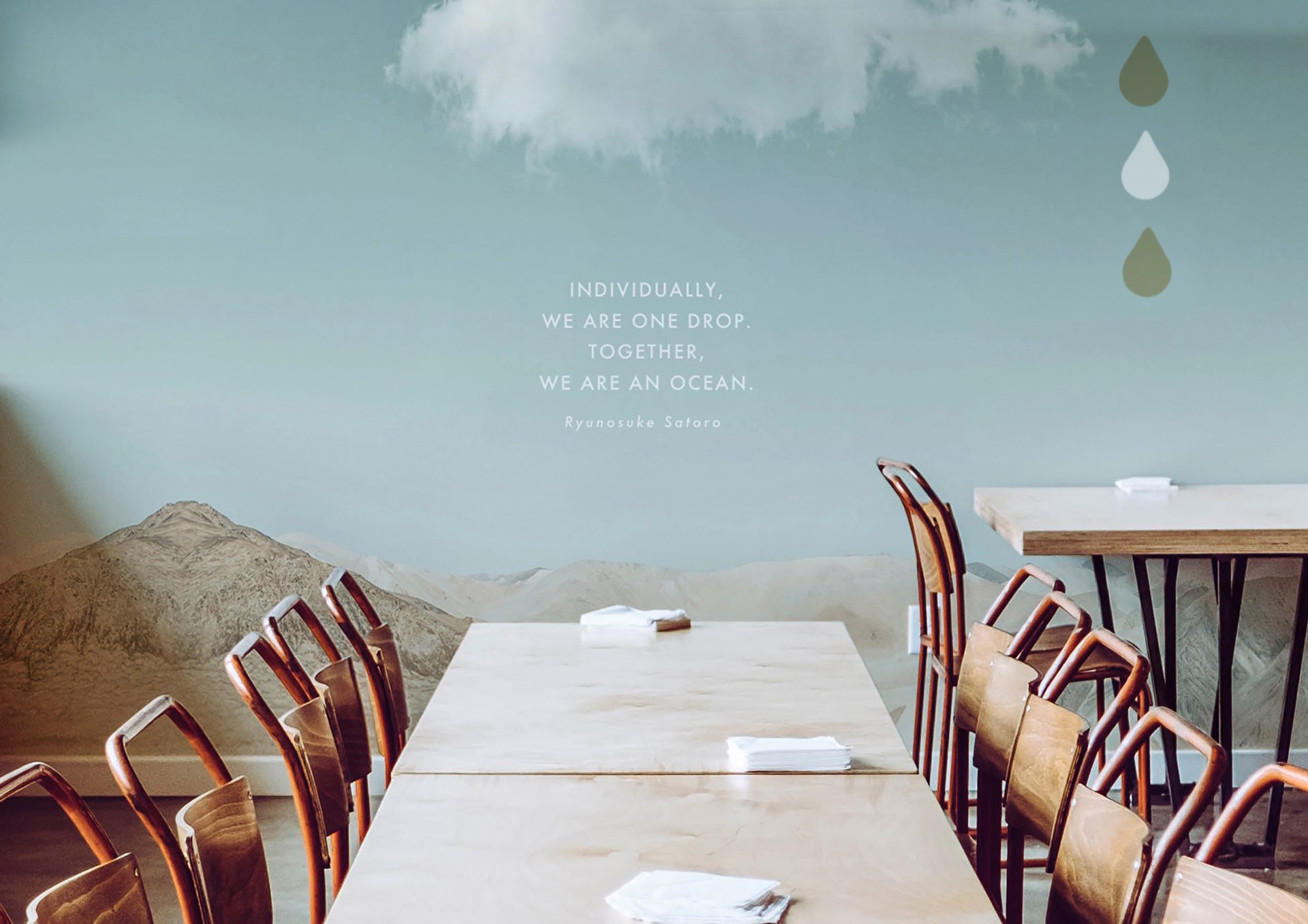 Dining room with sky, cloud, and mountain mural; quote: "We are one drop. Together, we are an ocean."