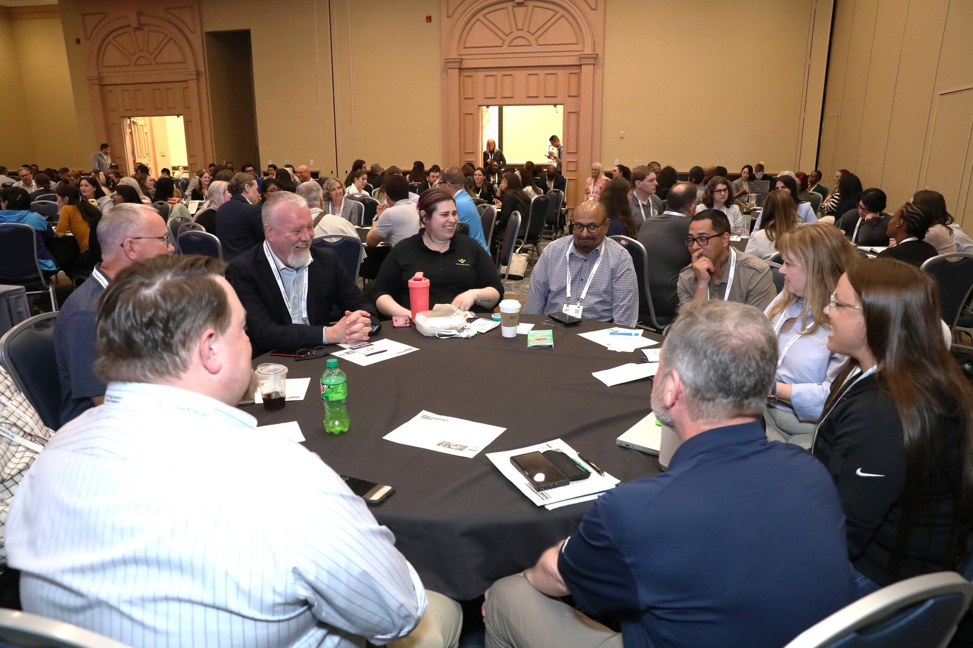 People seated around a round table at a conference, engaged in discussion.