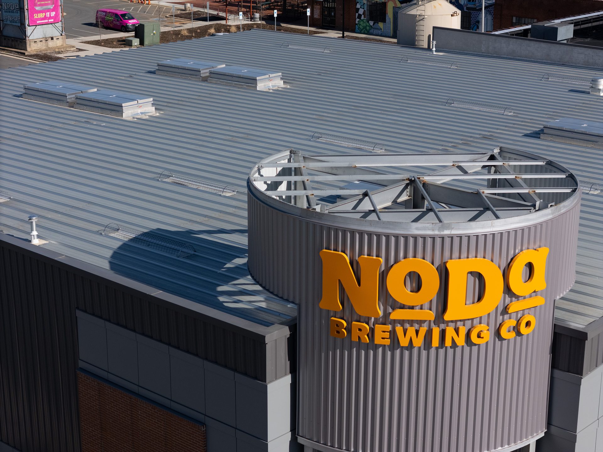 Noda Brewing Co. sign on a building with a corrugated metal roof and skylights.