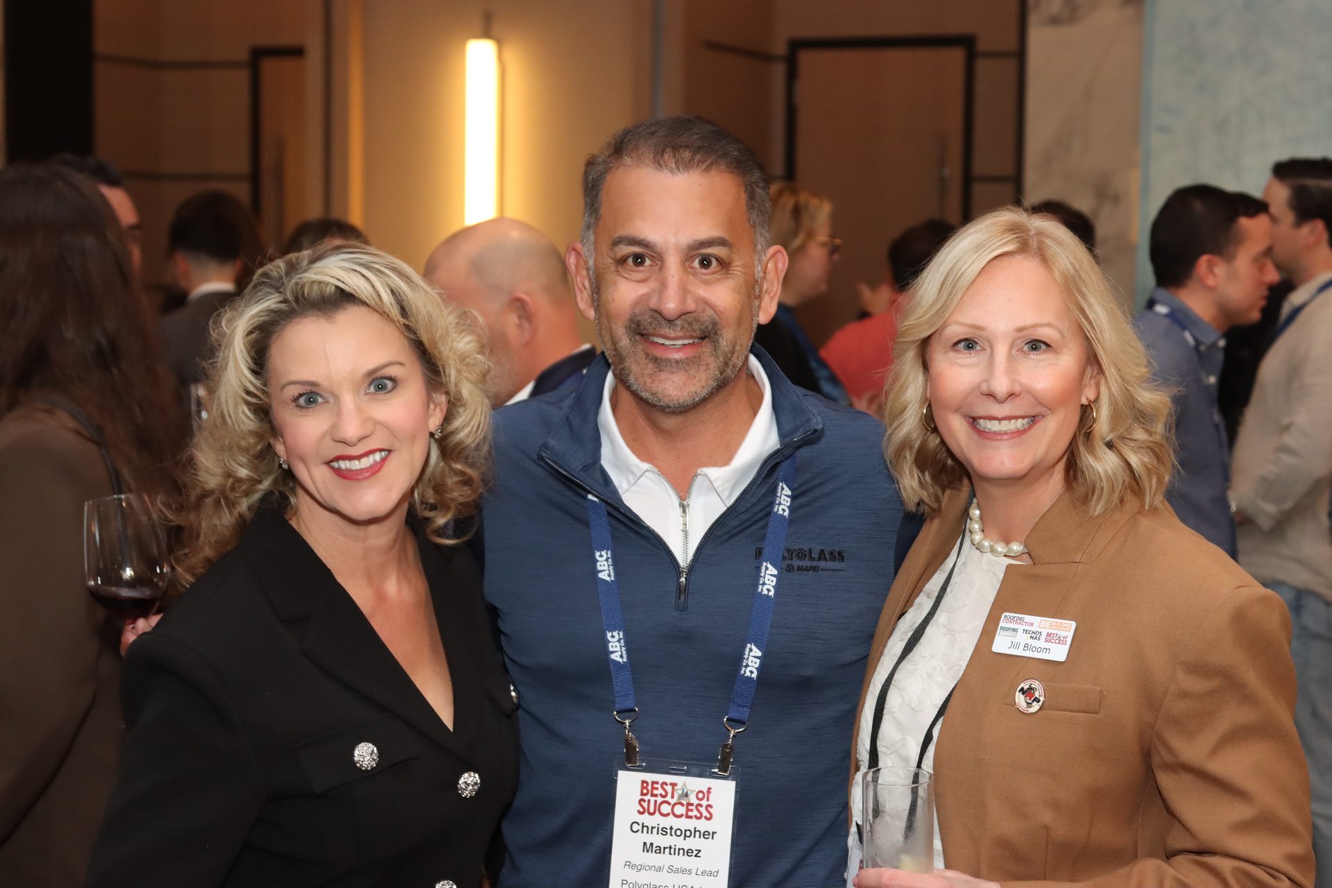 Three smiling people at a "Best of Success" event, including Christopher Martinez and Jill Bloom.